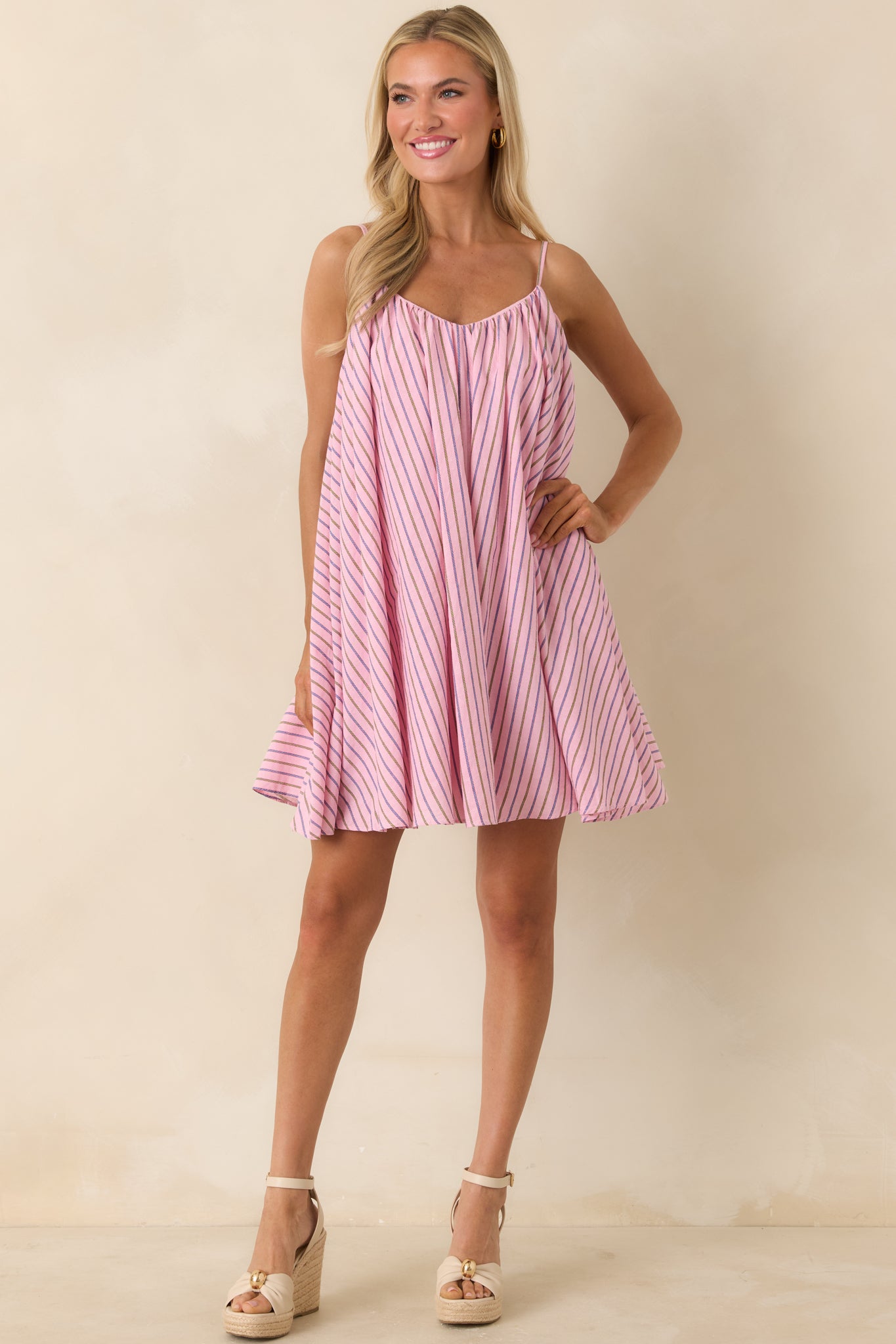 Pink striped mini dress with spaghetti straps and relaxed swing silhouette.