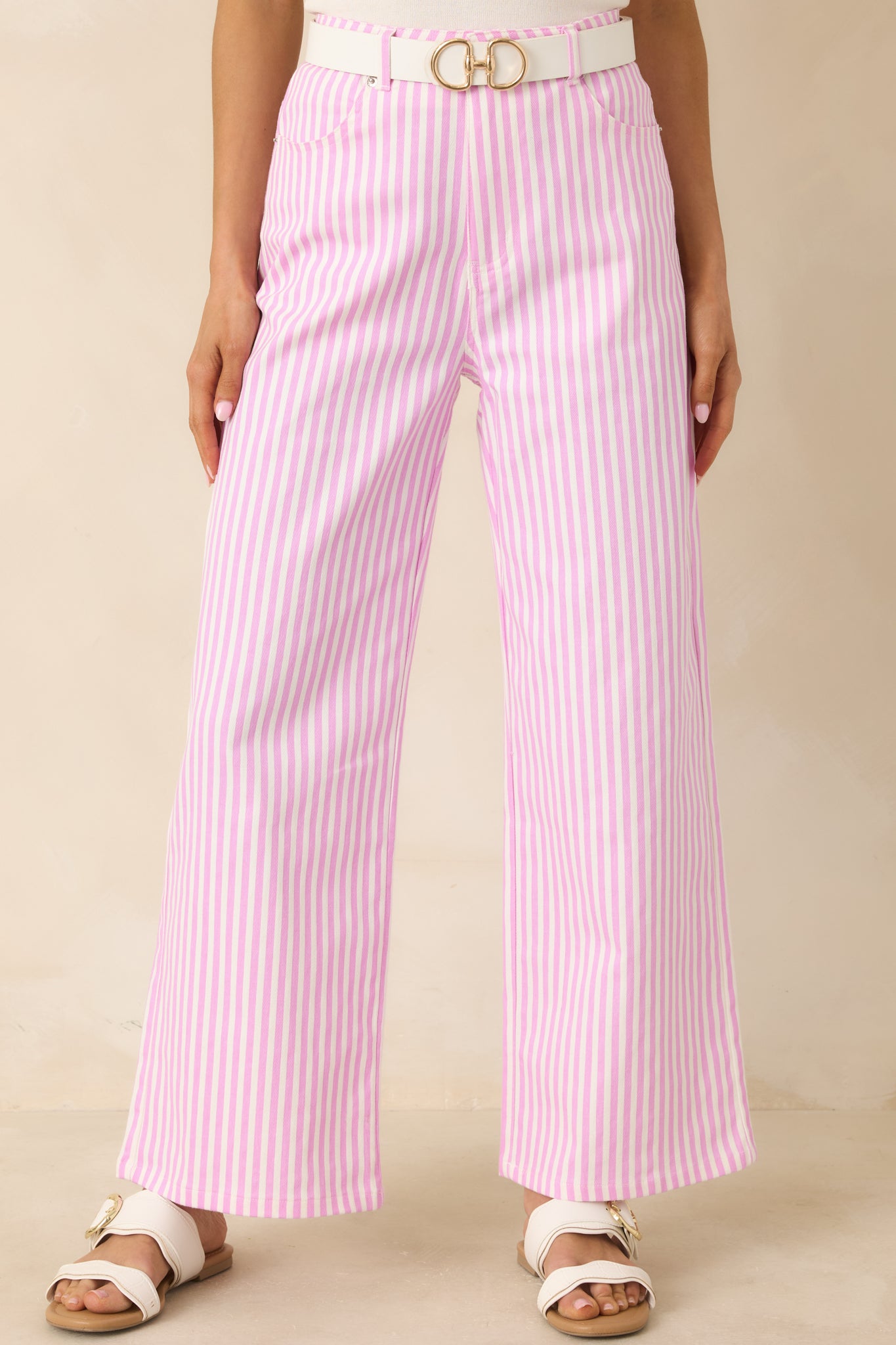 Pink striped pants highlighting clean tailoring and smooth cotton texture.