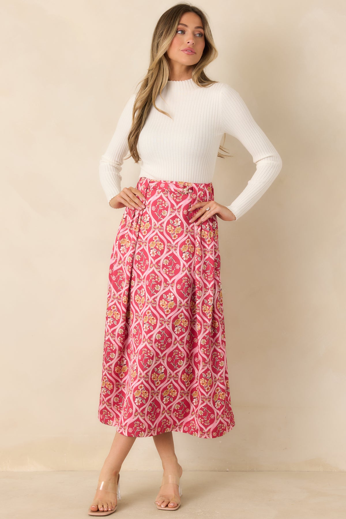 Pink trellis-print skirt decorated with multicolor florals and structured front pleats for added movement.