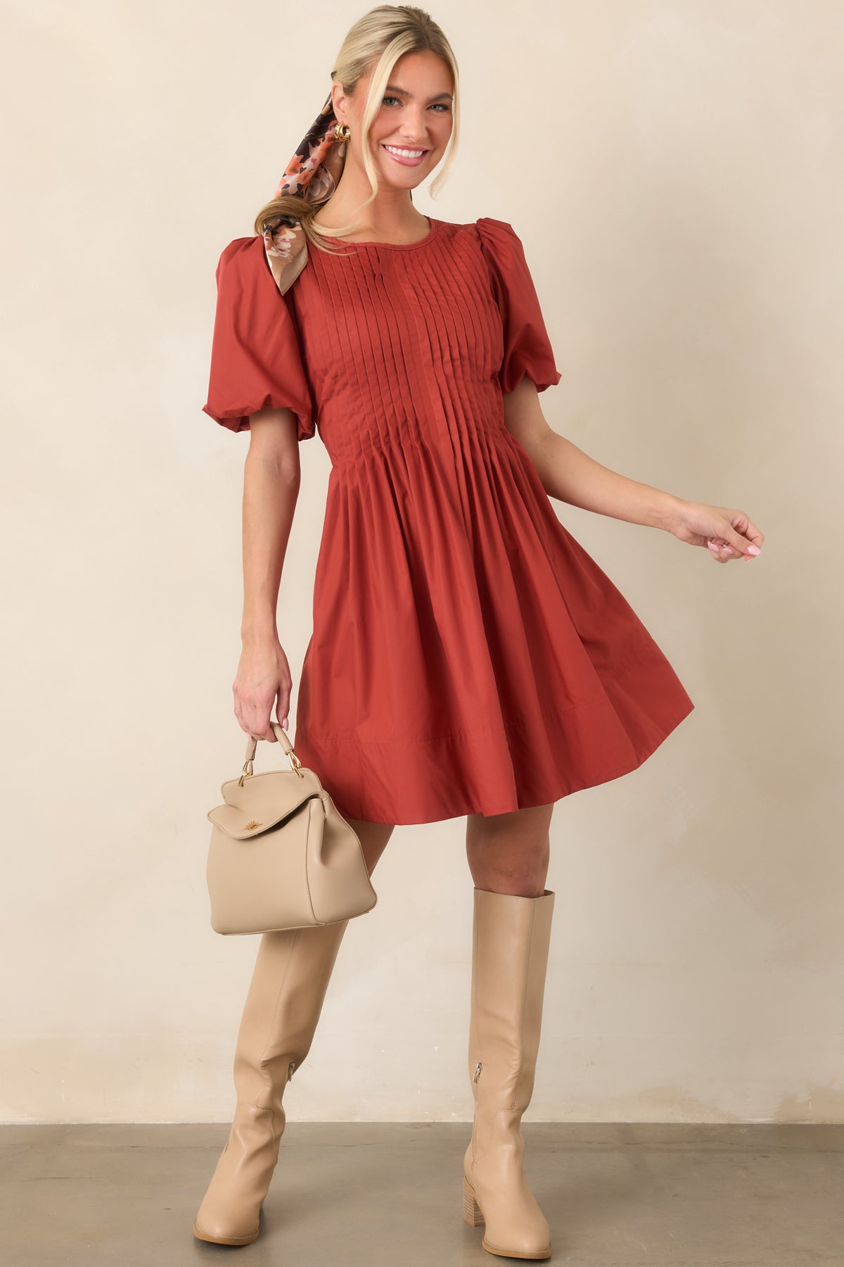 Pintucking across the bodice flows into a full, softly gathered skirt, complemented by voluminous short puff sleeves.