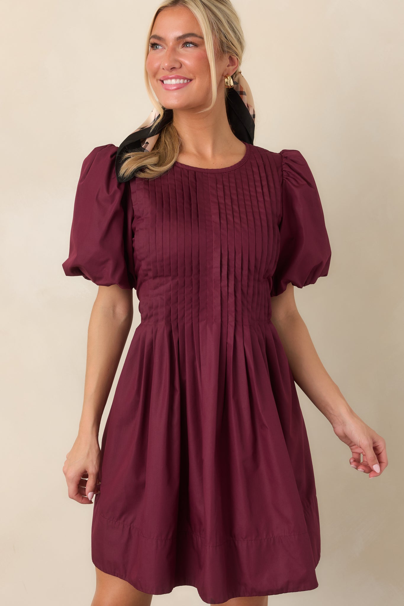 Detailed view of the dress showcasing the fine pintucked texture, voluminous puff sleeve, and softly gathered fabric through the waist.