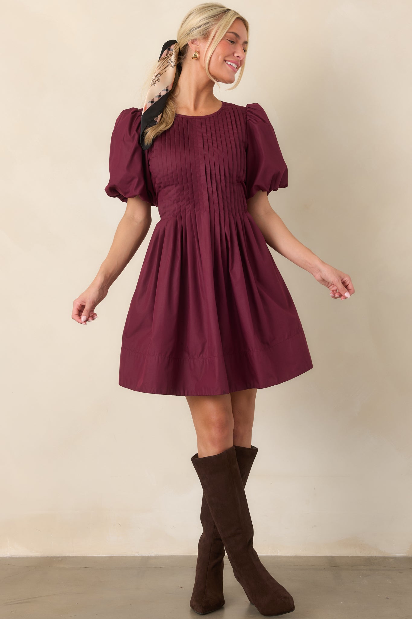 Pintucked mini dress featuring detailed front bodice pleating, voluminous short puff sleeves, a softly gathered full skirt, and a feminine flared silhouette.