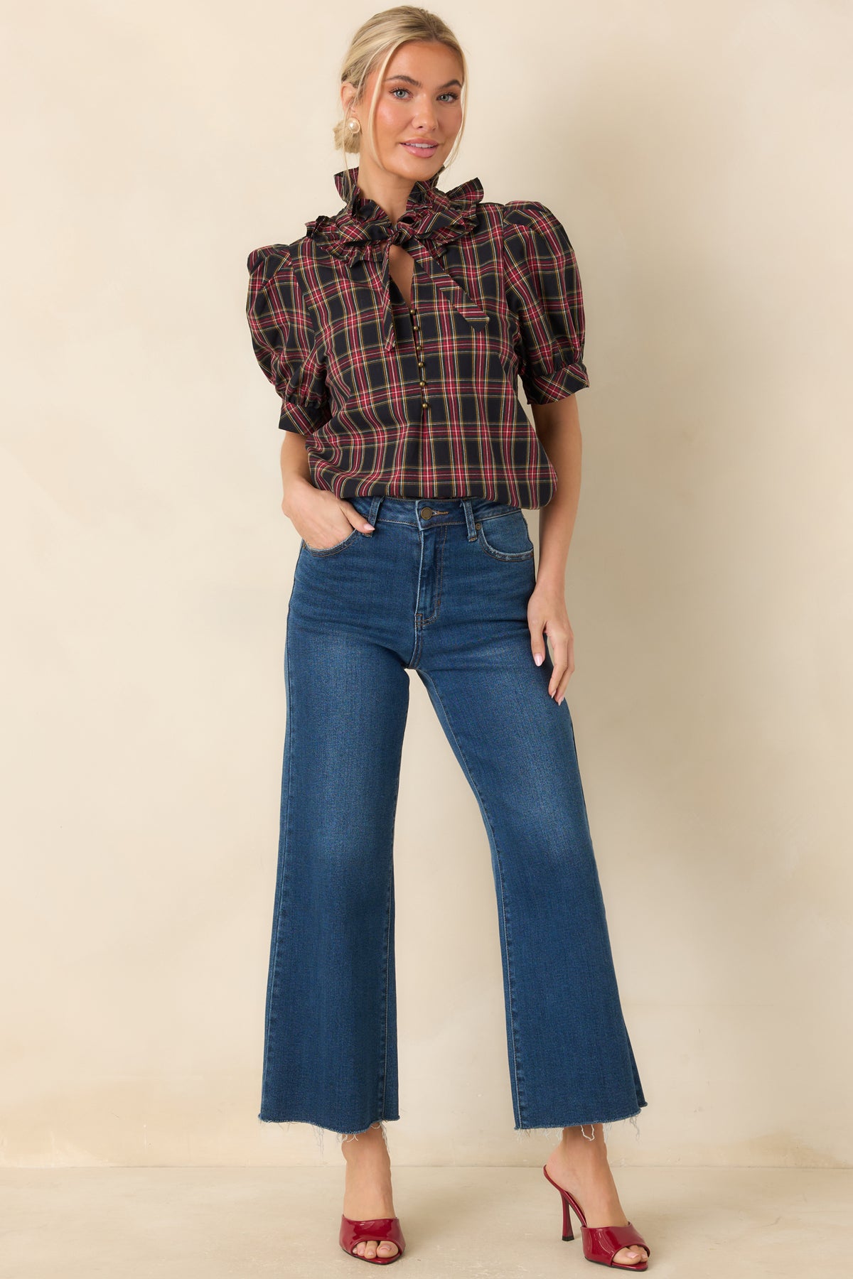 Plaid cotton blouse with a ruffled stand collar, statement bow, and short puff sleeves.