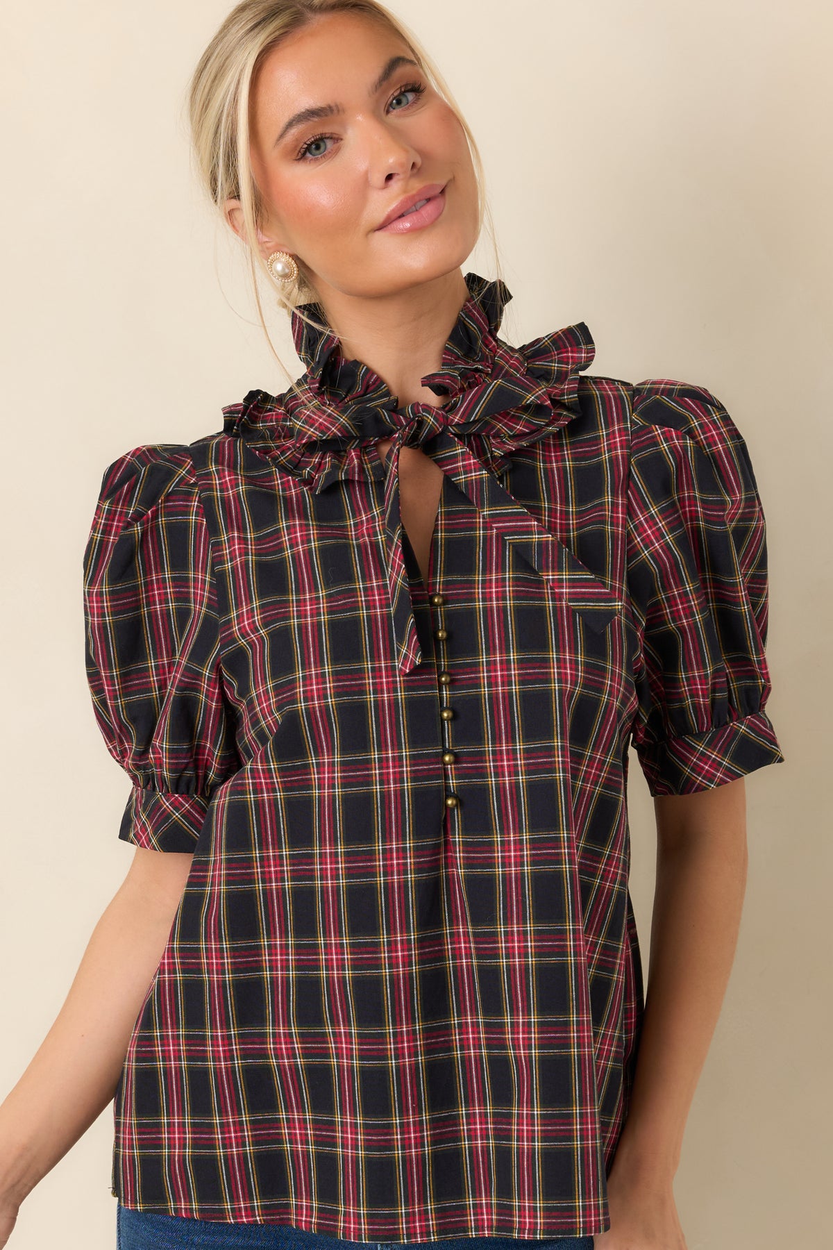 Plaid blouse neckline featuring a ruffled stand collar and matching oversized bow.