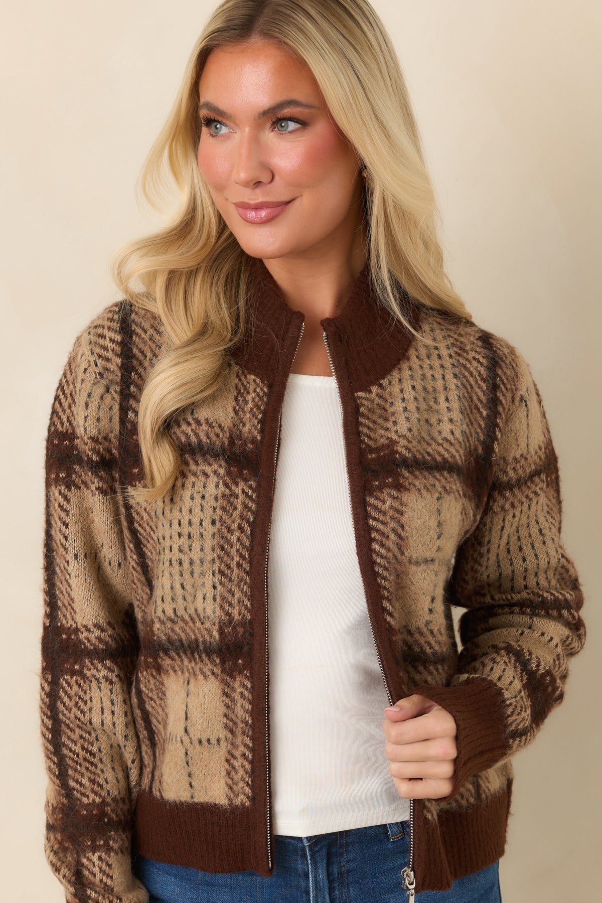 Close-up of the plaid cardigan showing its fuzzy knit texture, front zipper, and ribbed stand collar.