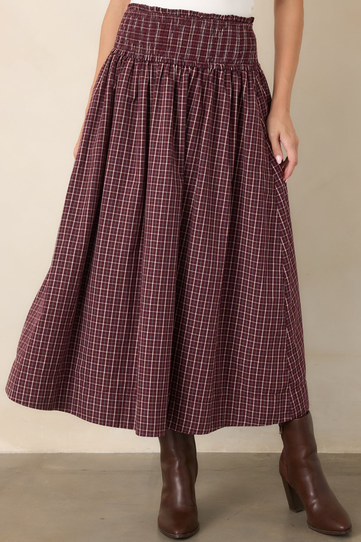 Detailed view of the skirt's side pocket, plaid cotton fabric, and softly gathered construction.