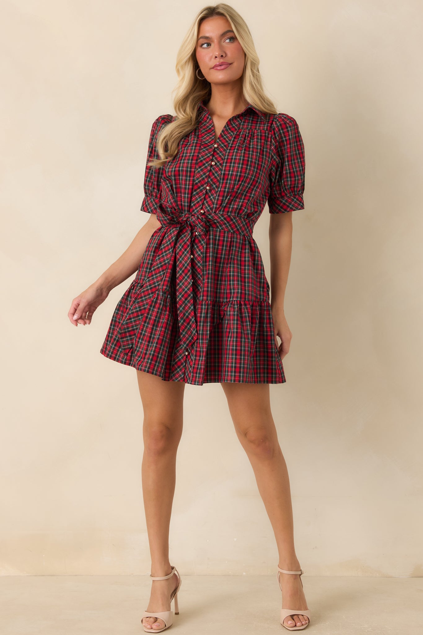 Red and green plaid dress featuring a classic collar, functional gold-tone buttons, fit-and-flare shape, and playful tiered hem.