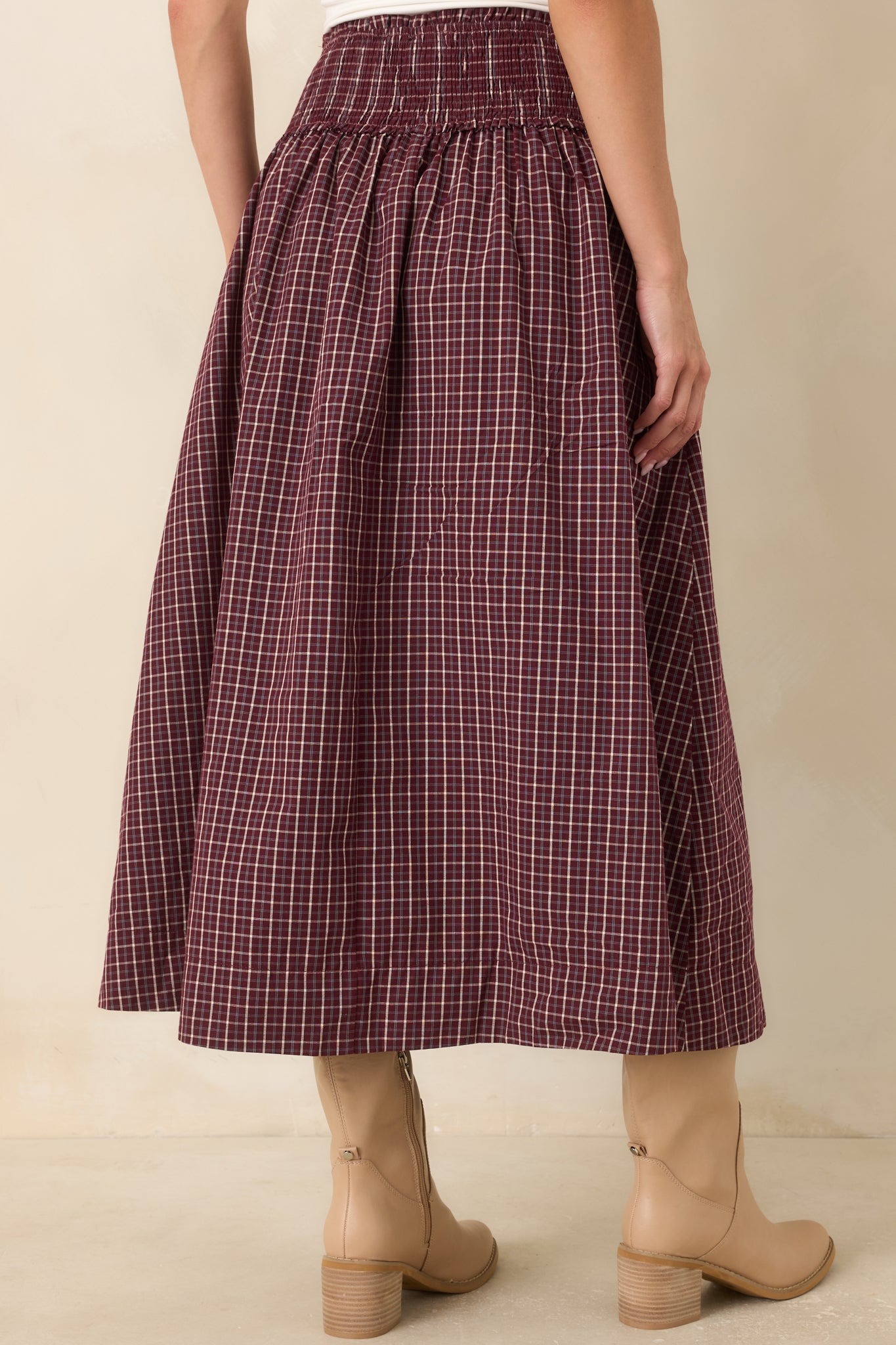 Rear view of the plaid maxi skirt showcasing the wide smocked drop waist, gathered full skirt, flowing silhouette, and classic burgundy, ivory, and light blue plaid pattern.