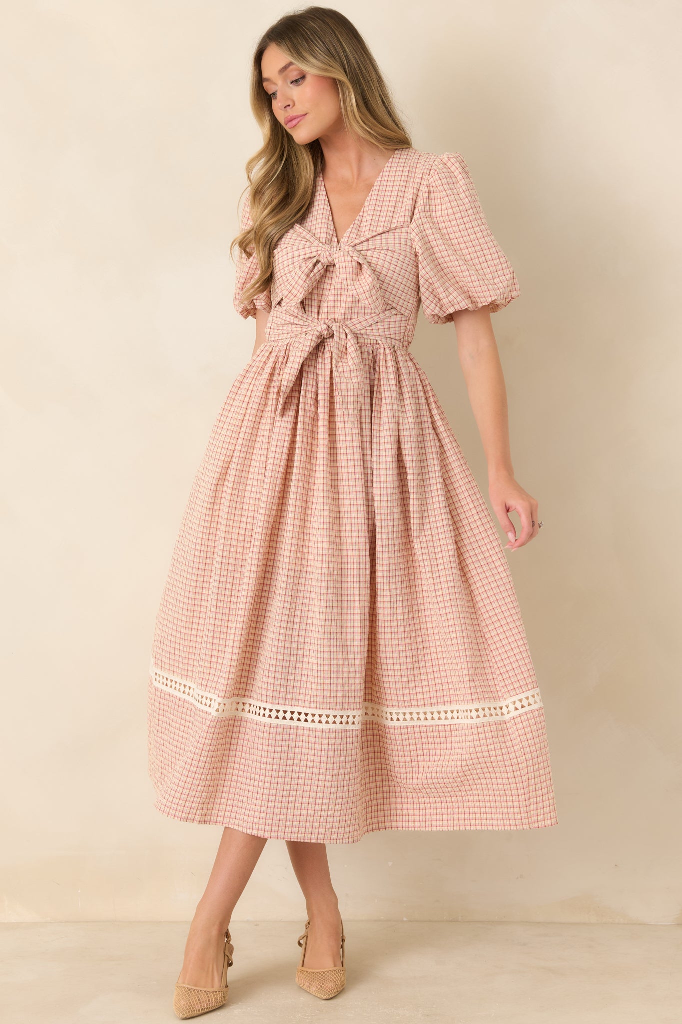 Plaid midi dress highlighting its fitted upper silhouette, softly gathered waist, rounded puff sleeves, and sweeping full skirt with a textured hem inset.