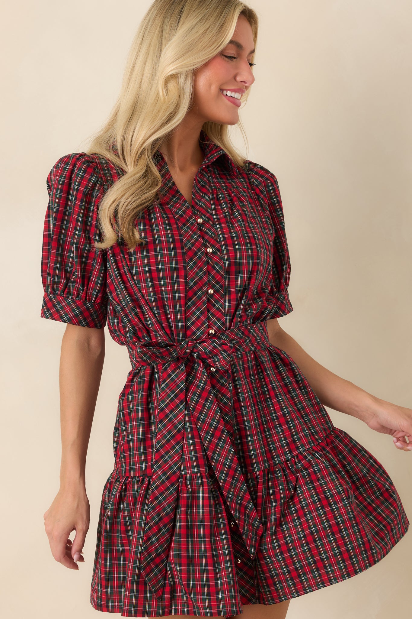 Close view of the plaid mini dress highlighting the collared neckline, gold-tone buttons, and gathered puff sleeves.