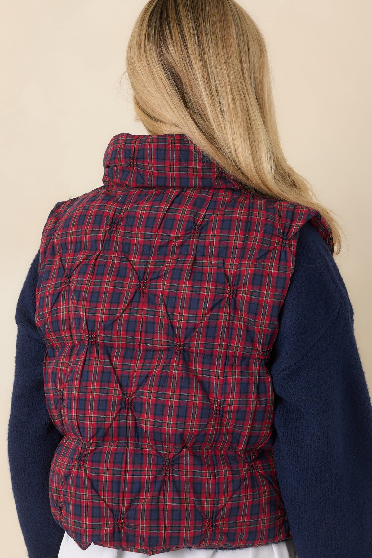 Rear view of the plaid quilted vest showing the rounded stitching and relaxed back panel.