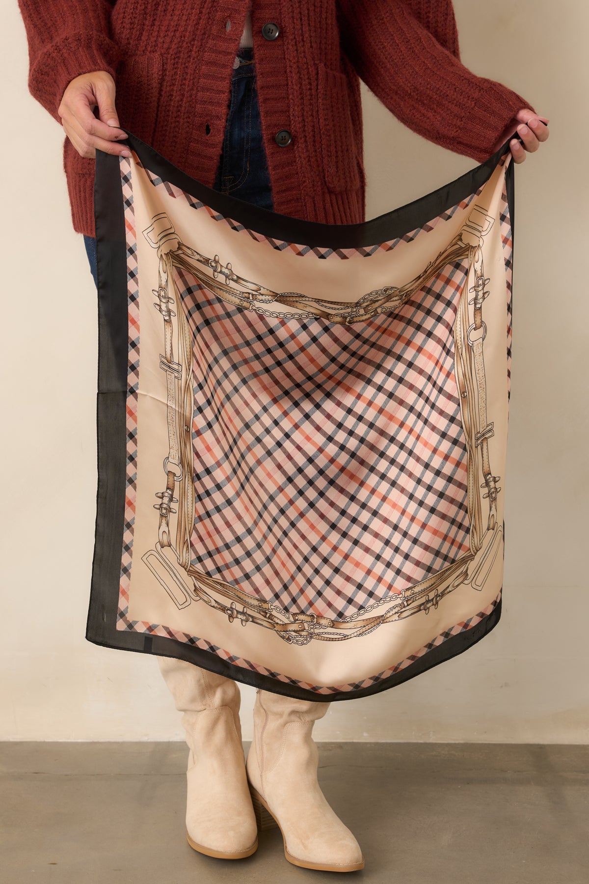 Spread-out square scarf showcases the neutral plaid center surrounded by ornate bridle, chain, and leather strap designs.