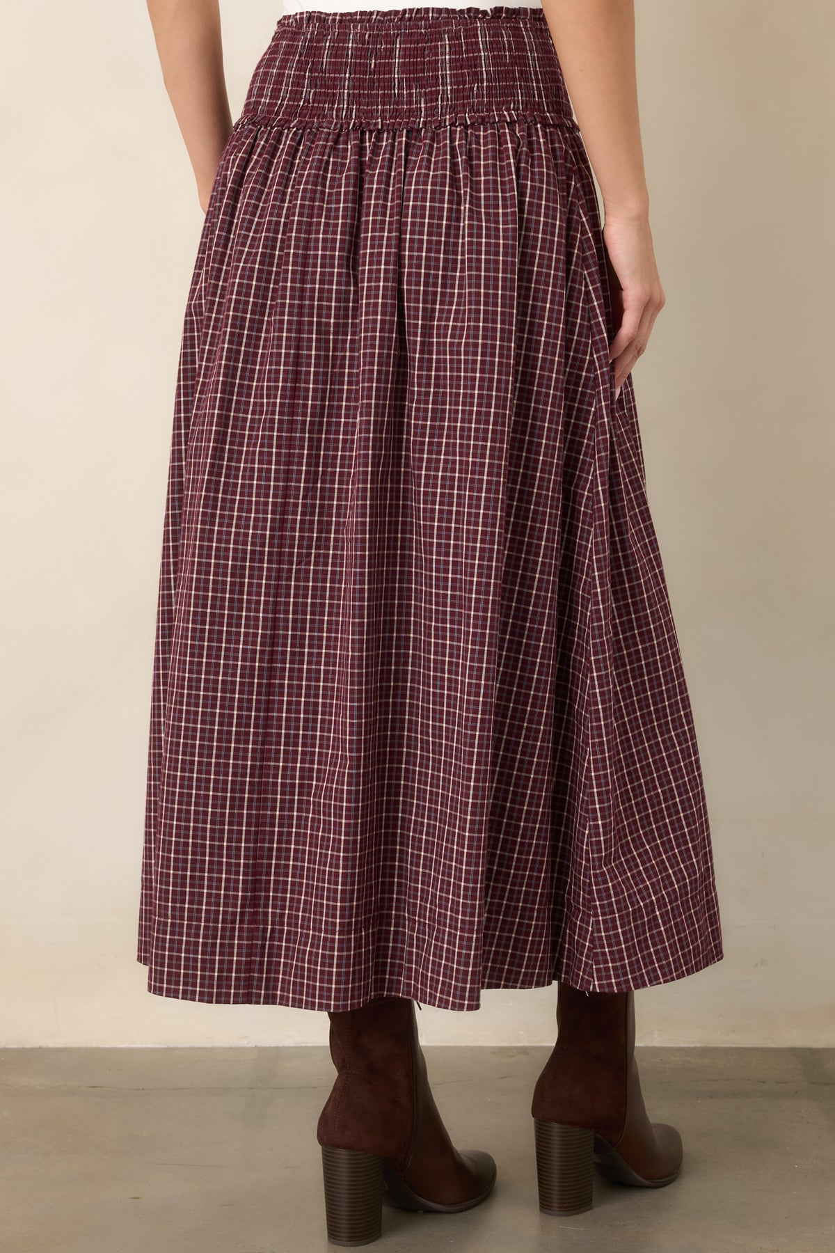 Rear view of the plaid maxi skirt showing the wide smocked drop waist, gathered full skirt, and flowing ankle-length silhouette.