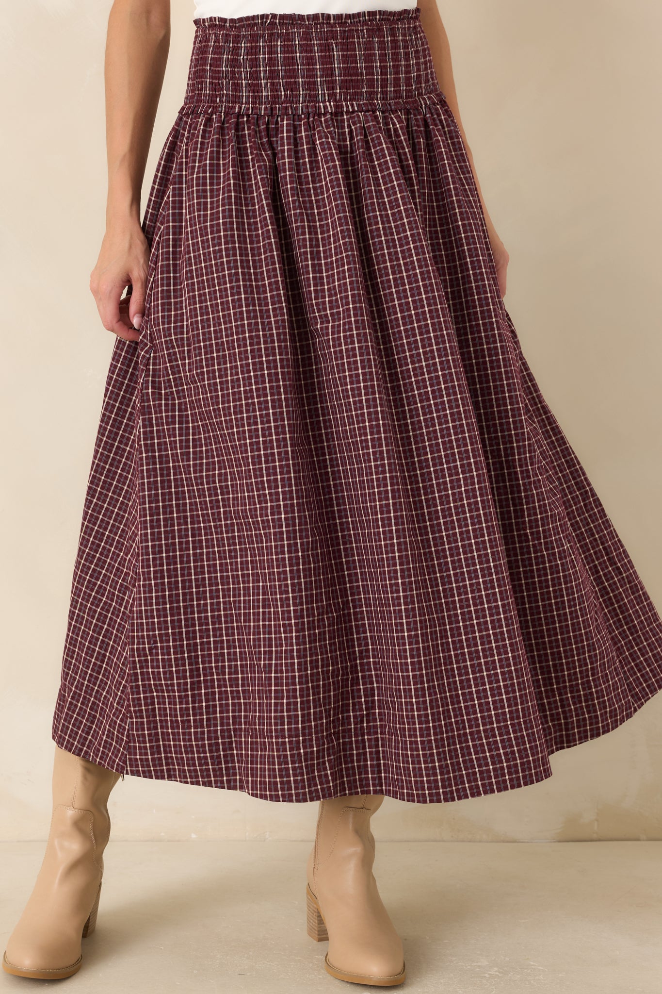Close view of the burgundy, ivory, and light blue plaid fabric highlighting the wide smocked drop waist, soft ruffle trim, and comfortable stretch construction.