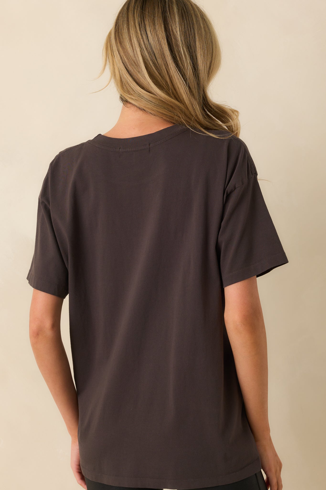 A back view of the tee showing the plain black back with an oversized, straight-hem silhouette.