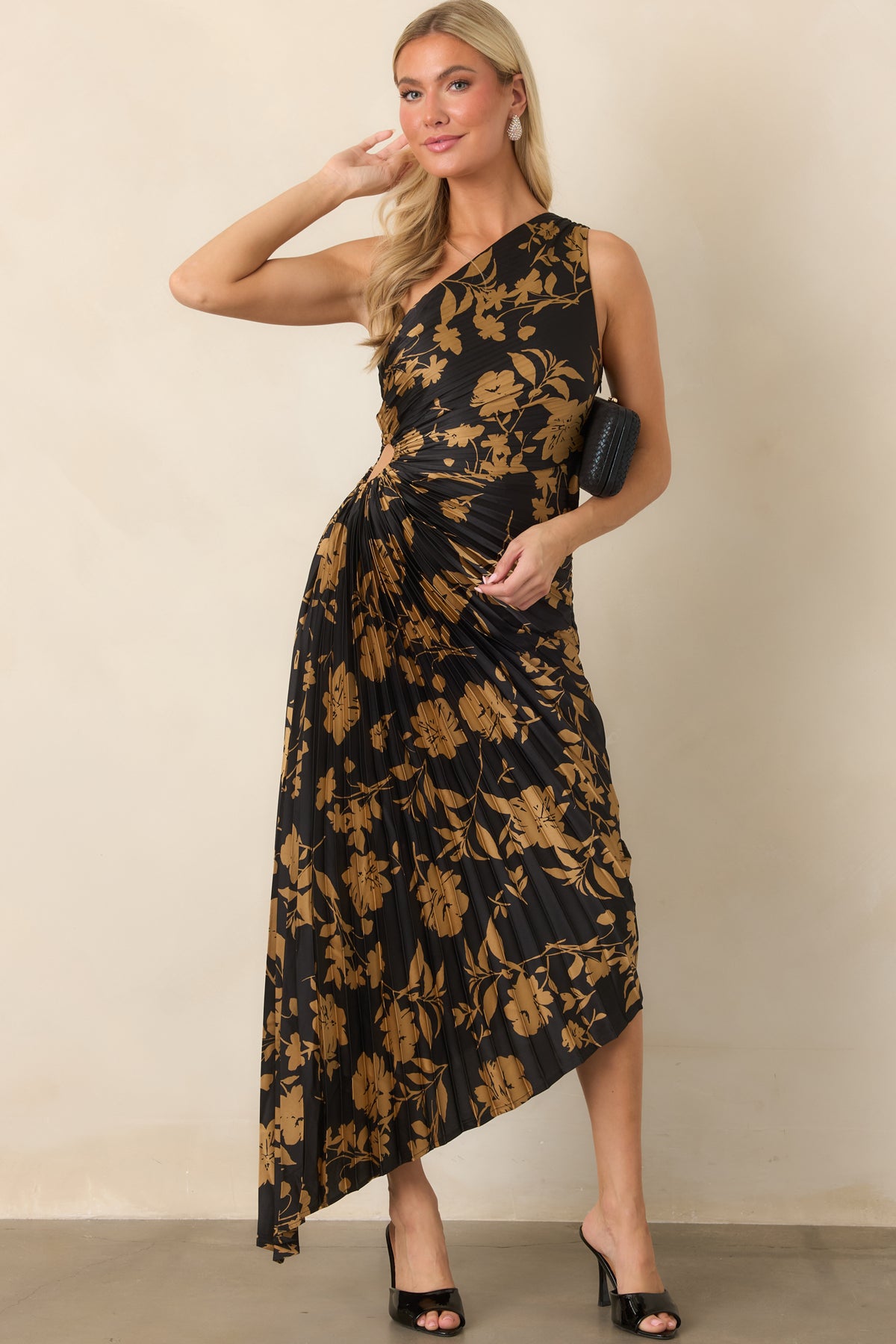 Pleated black satin dress features a defined waist with ruching and an asymmetrical high-low hem.