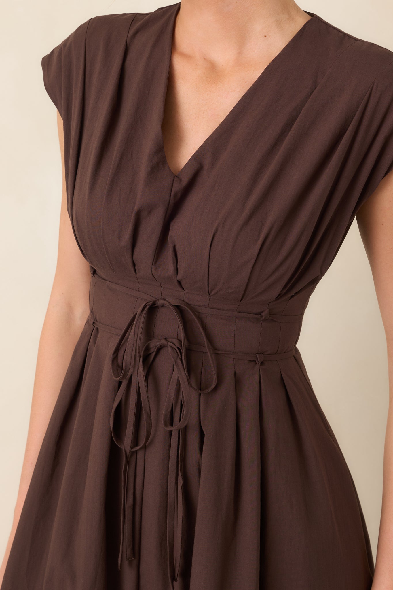 Close-up of the dress’s pleated bodice and double strand self-tie belt, highlighting the delicate texture and defined waist.