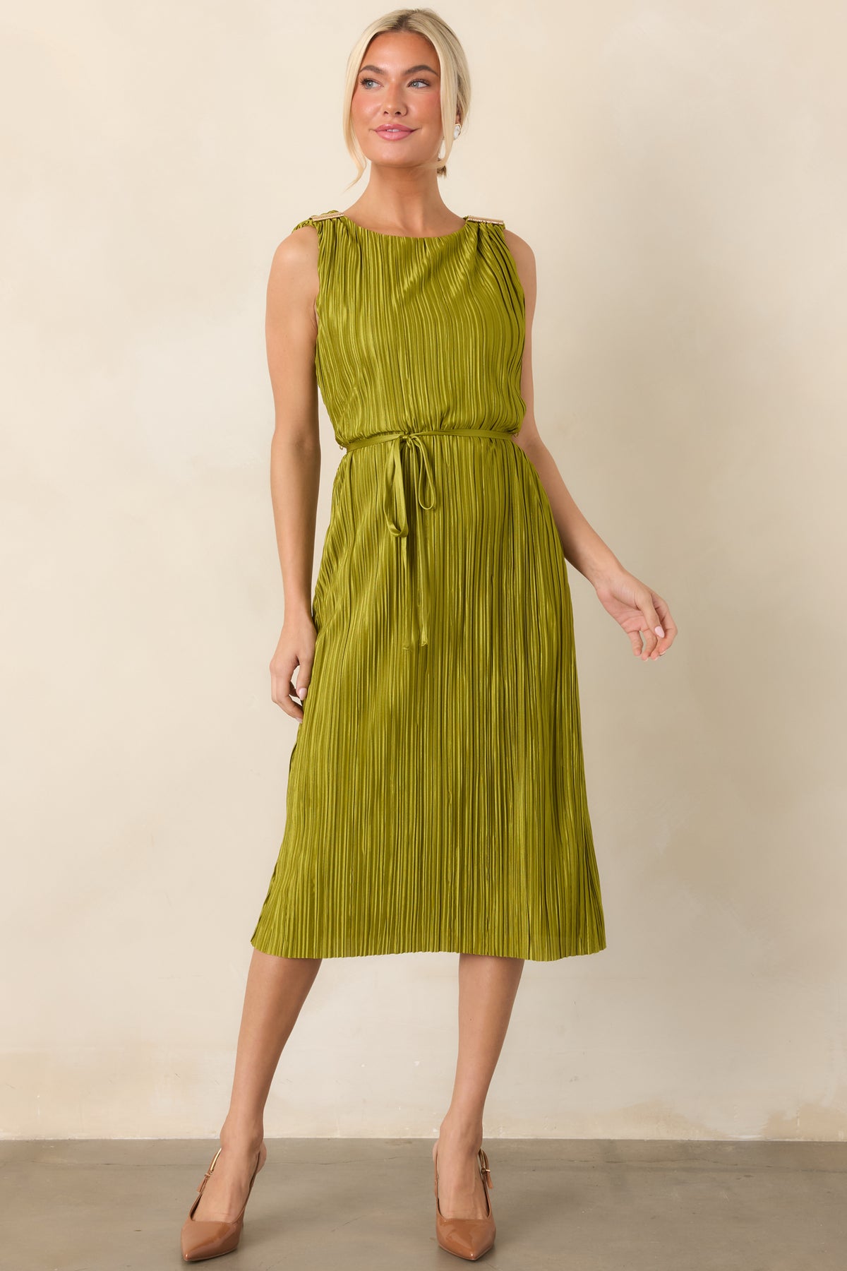 Pleated midi dress featuring a subtle light-catching sheen, streamlined shape, decorative gold shoulder details, and a softly cinched waist.