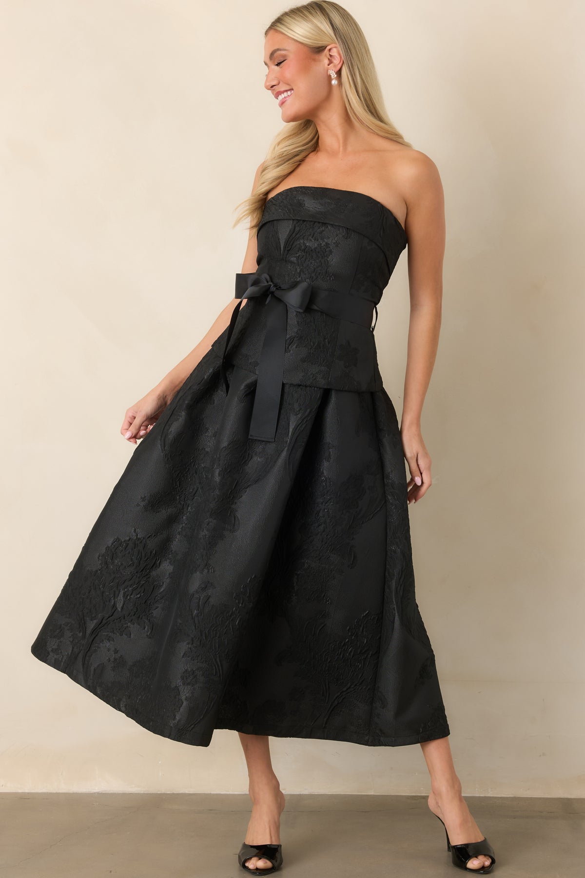 Full pleated midi dress with a structured bodice, oversized waist bow, and graceful A-line silhouette.