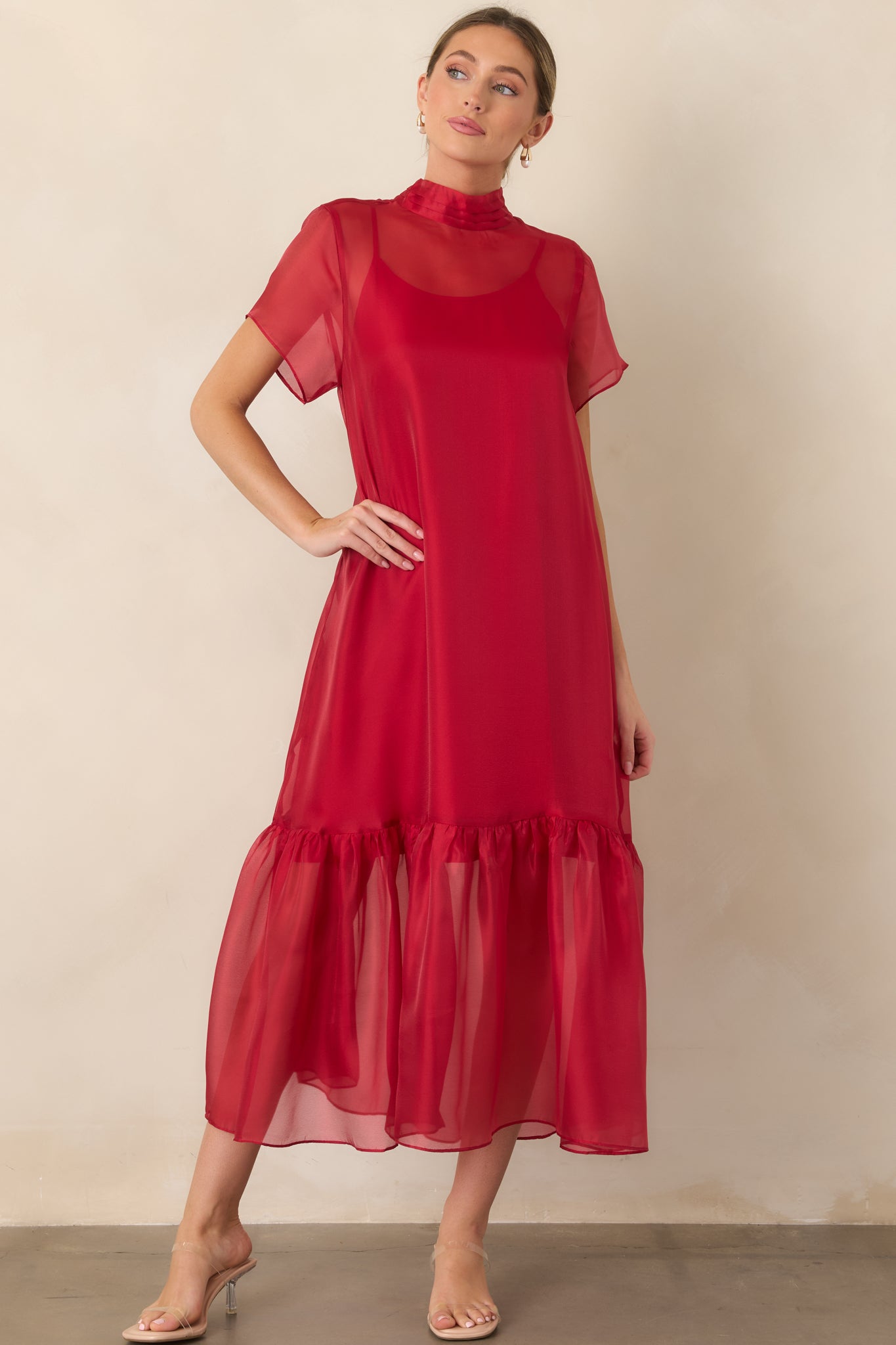 Organza overlay dress designed with a pleated high neckline, sheer sleeves, layered construction, and a full-length gathered silhouette.