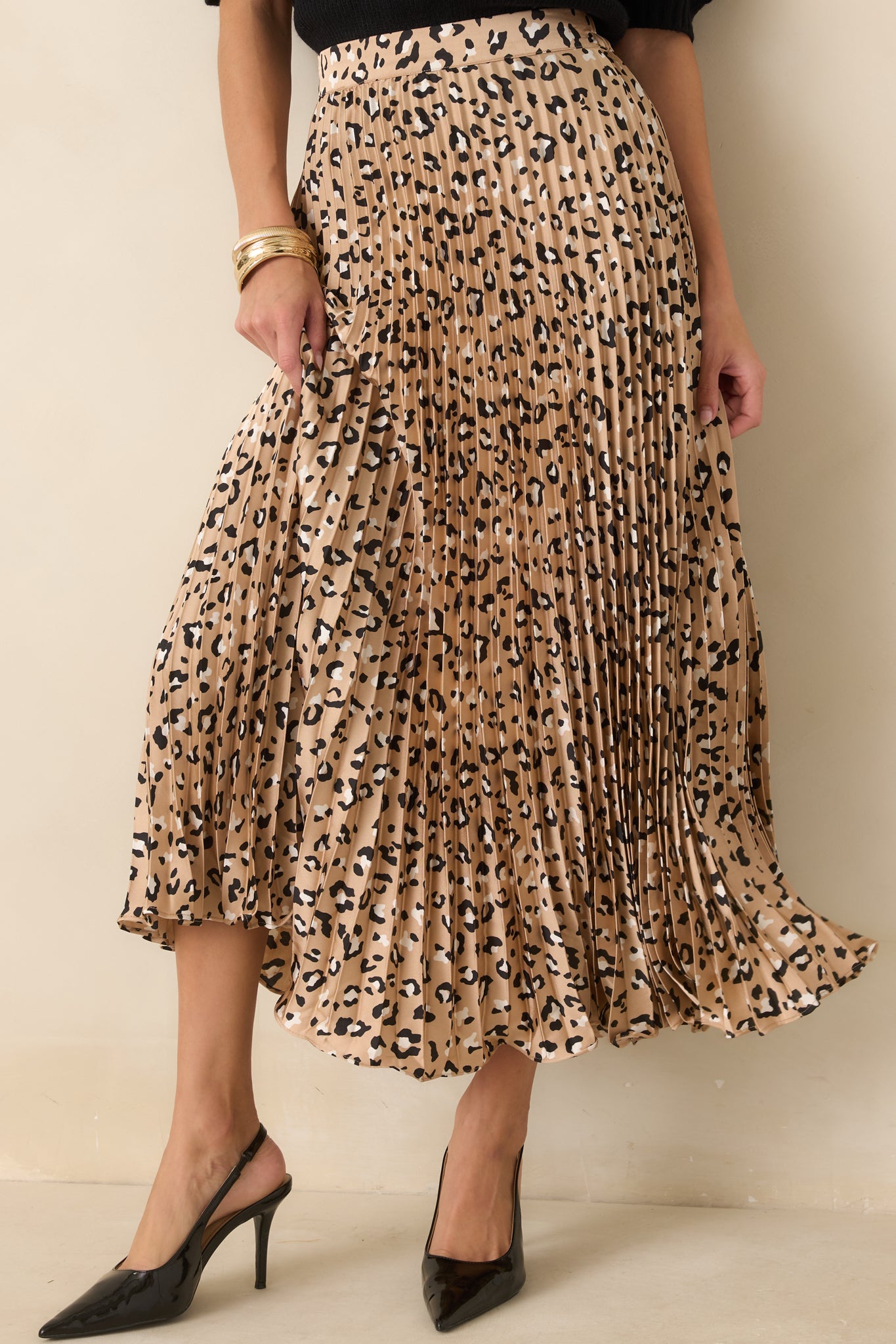 Detailed view of the finely pleated satin fabric showcasing the dimensional texture and leopard print pattern.
