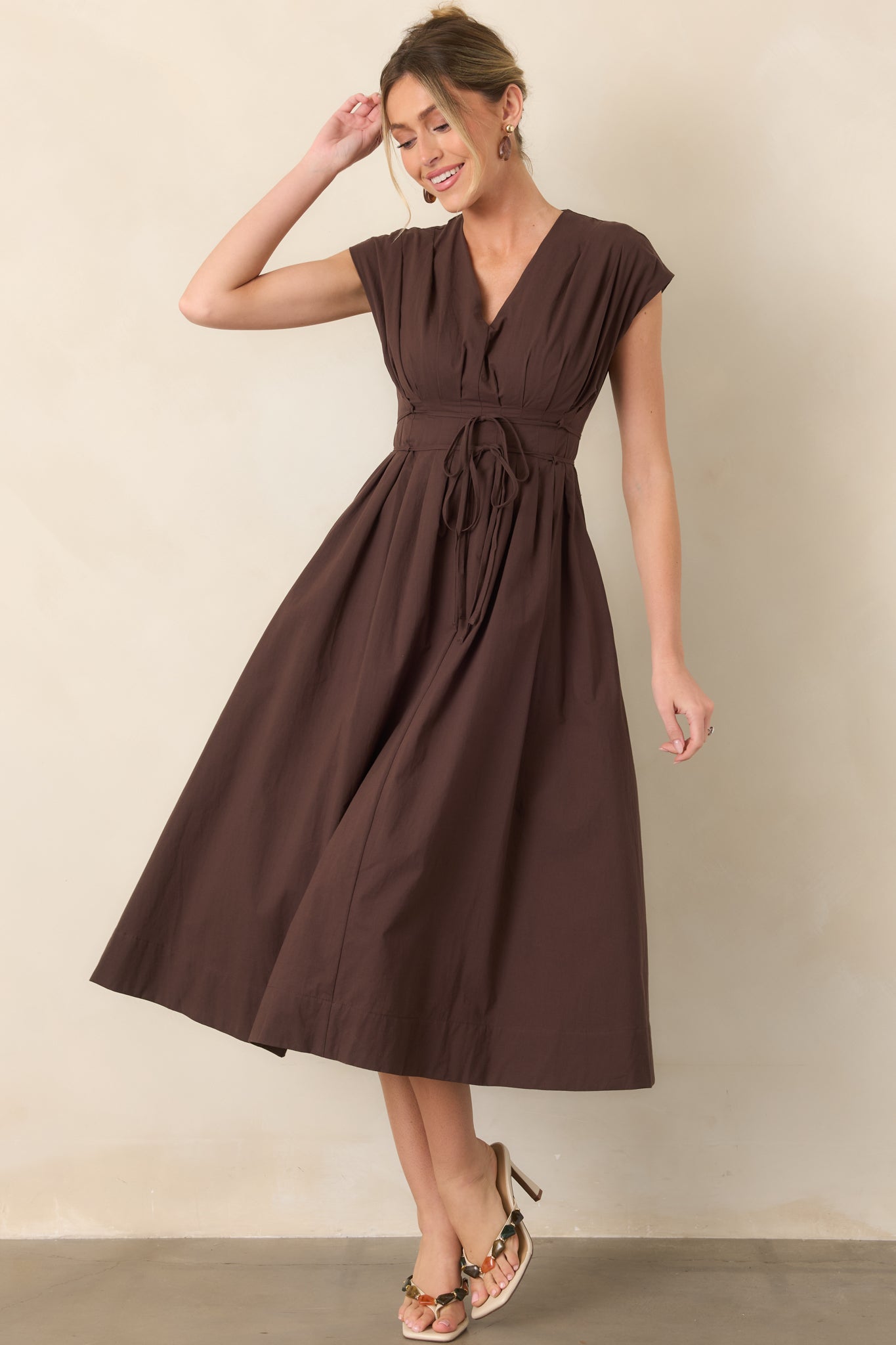 Midi dress with a V-neckline, cap sleeves, softly pleated bodice and skirt, self-tie double strand waist belt, and gathered silhouette.