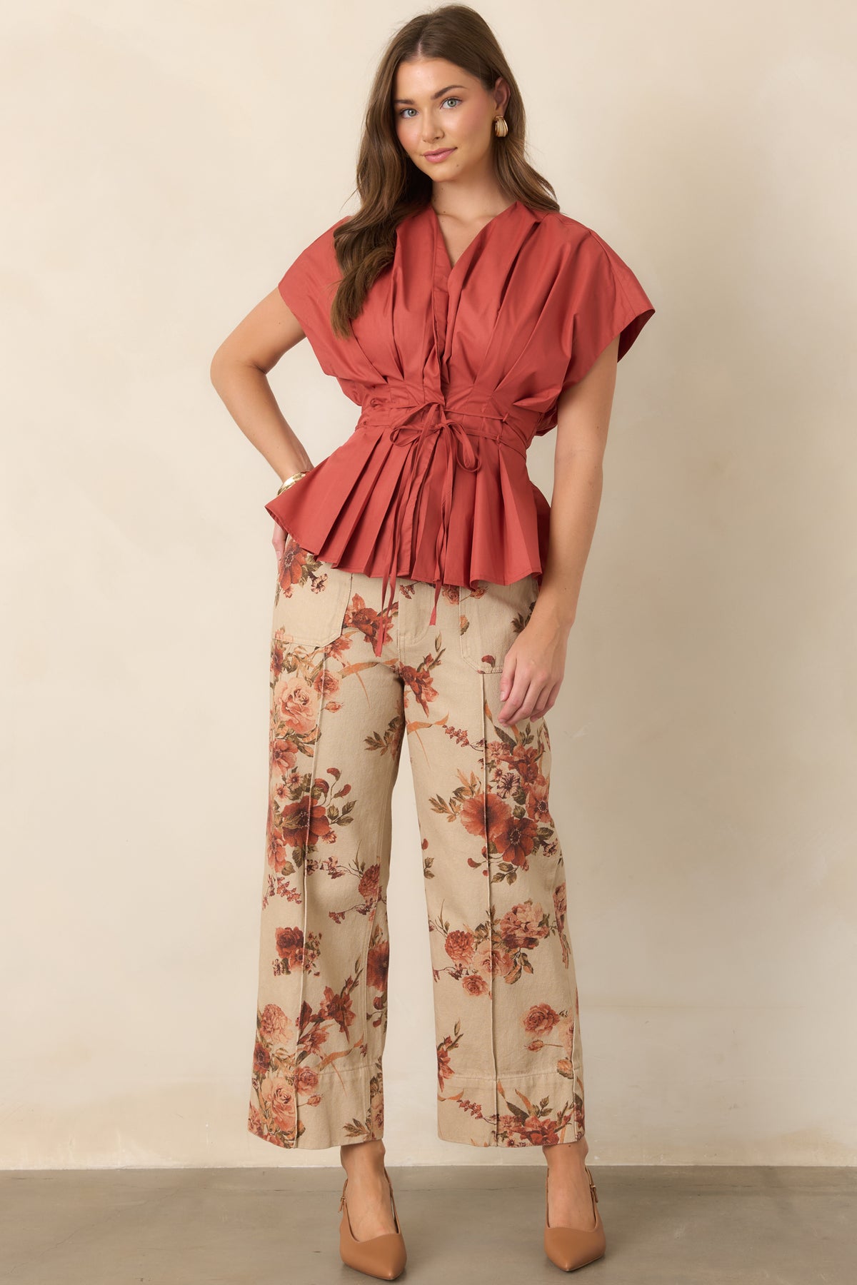 Top featuring crisp pleating through the V-neckline and bodice, dramatic short sleeves, waist ties, and a flared peplum hem.
