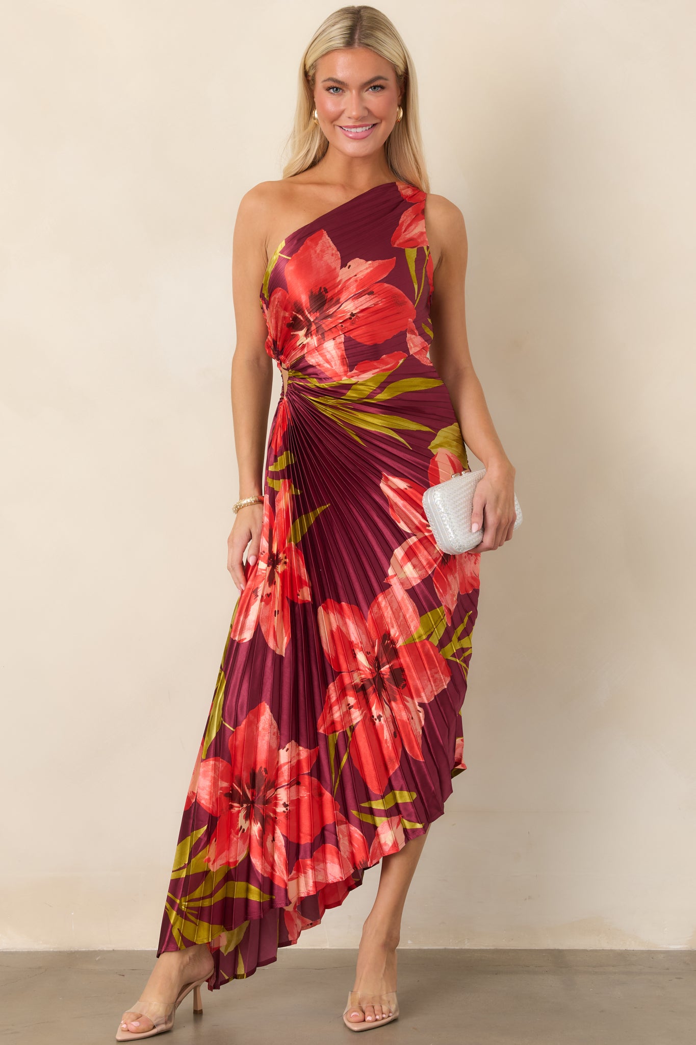 Rich plum dress showcasing sculpted pleats, a one-shoulder silhouette, waist ruching, and an elegant asymmetrical hemline.
