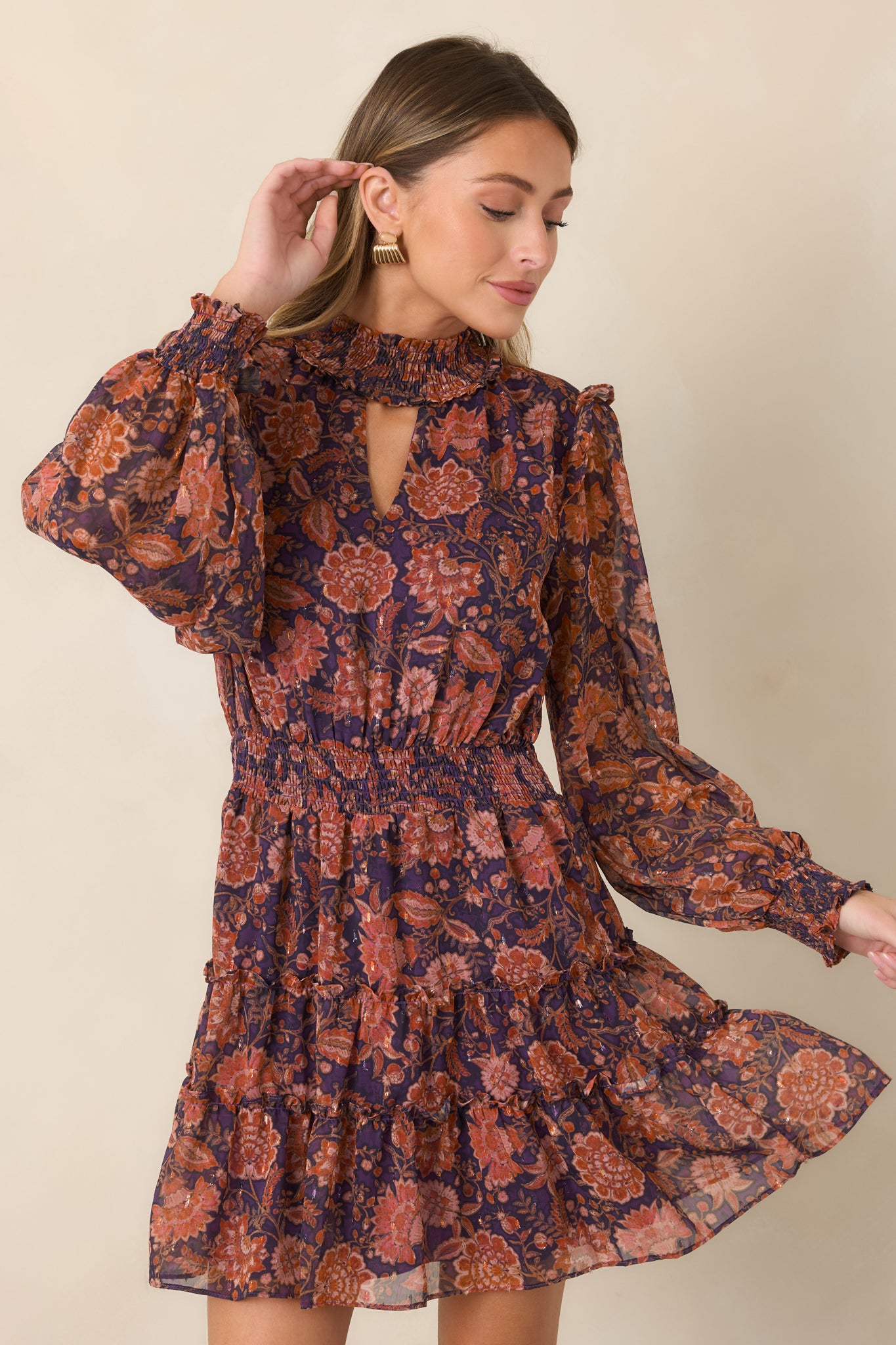 Close view of the smocked high neckline, keyhole detail, and sheer floral overlay in deep plum.