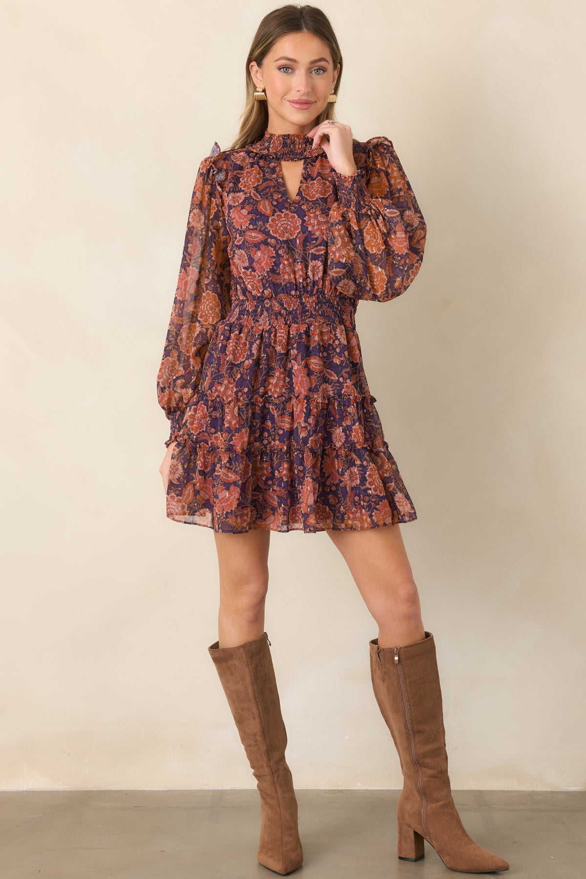 Deep plum dress with a high smocked neckline, keyhole detail, puffed sleeves, and flowing tiered mini silhouette.