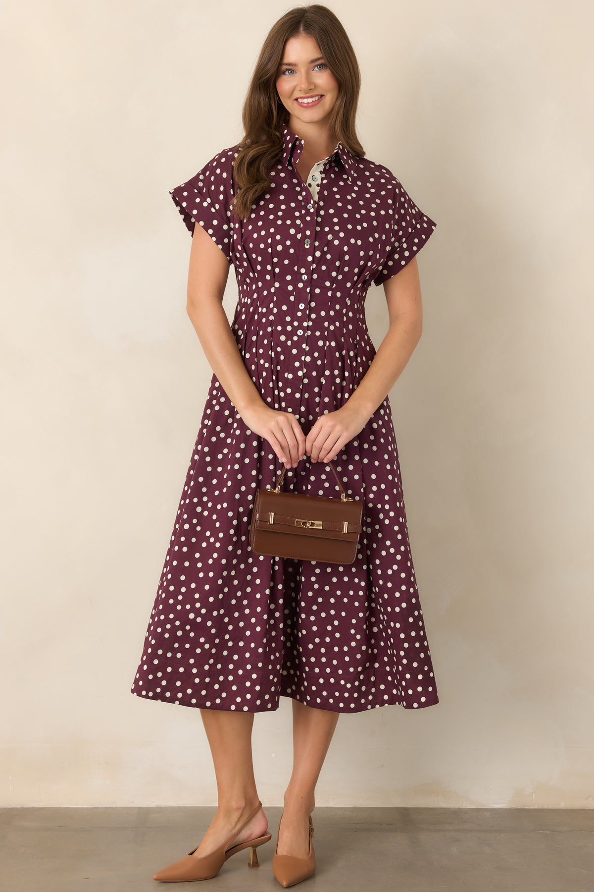 Cotton midi dress featuring plum polka dots, an ivory contrast button placket, short sleeves, tailored waist seams, and a flattering fit-and-flare silhouette.