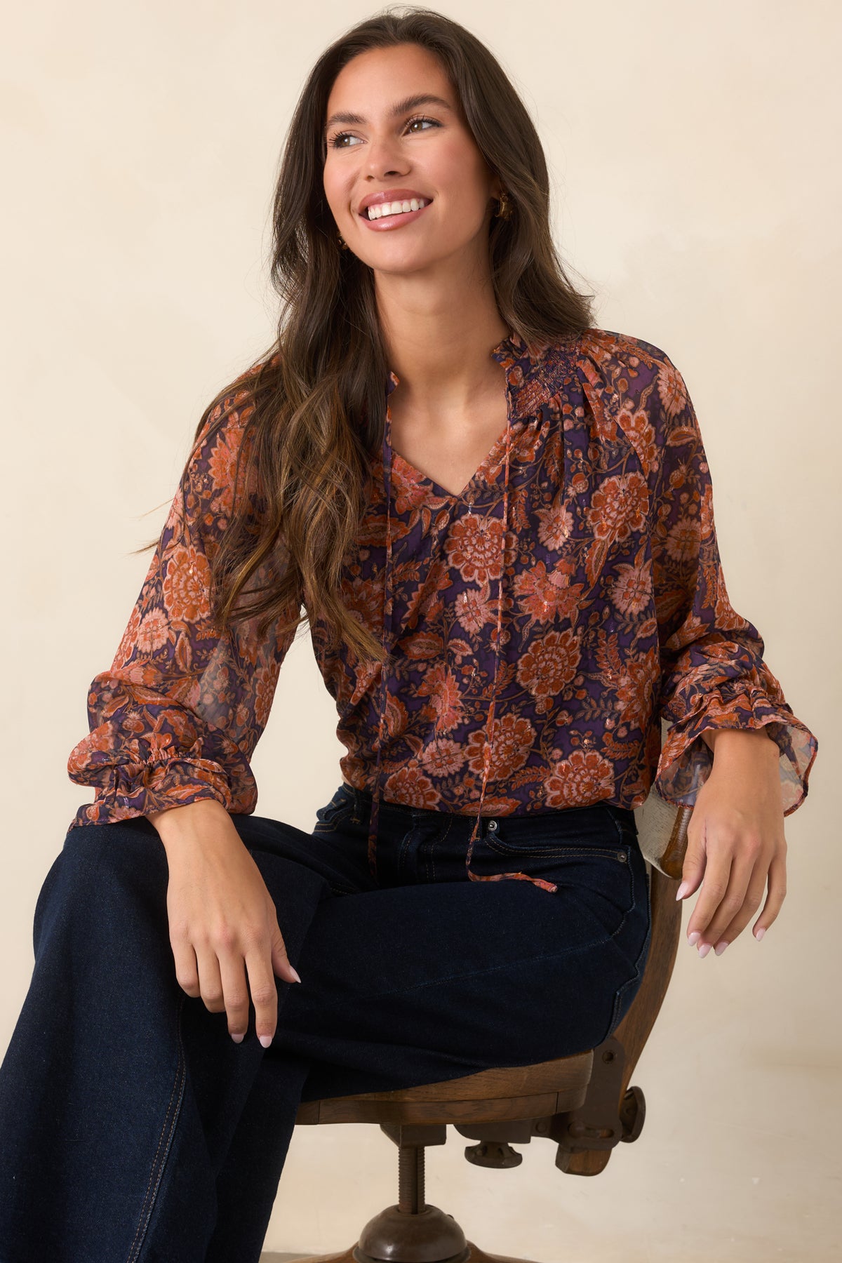 Floral top with a sheer plum, rust, coral, and muted pink overlay, ruffled split neckline, and long sleeves.