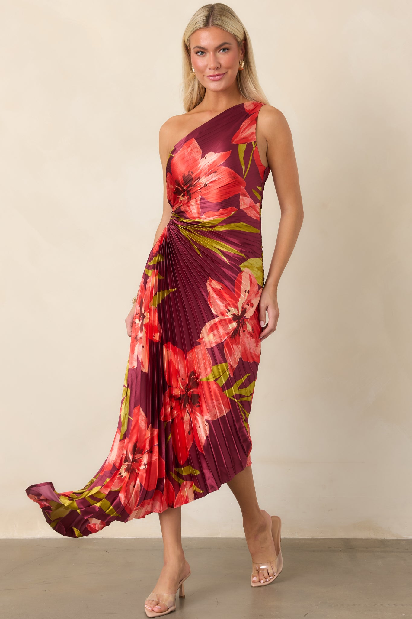 Plum satin dress showcasing the vibrant hibiscus pattern, sculpted one-shoulder neckline, ruched waist, and flowing high-low hem.