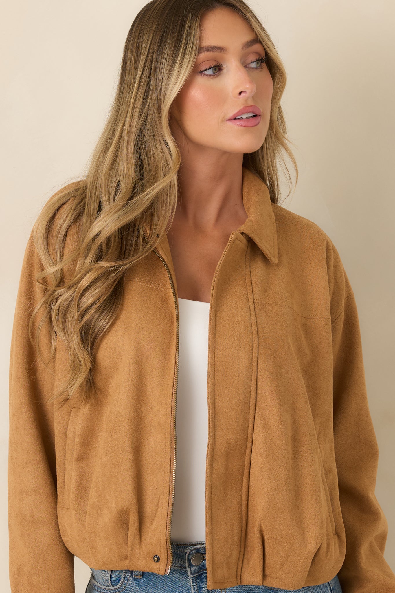 Close view of the jacket highlighting the pointed collar, concealed zip-front closure, and smooth faux suede texture.