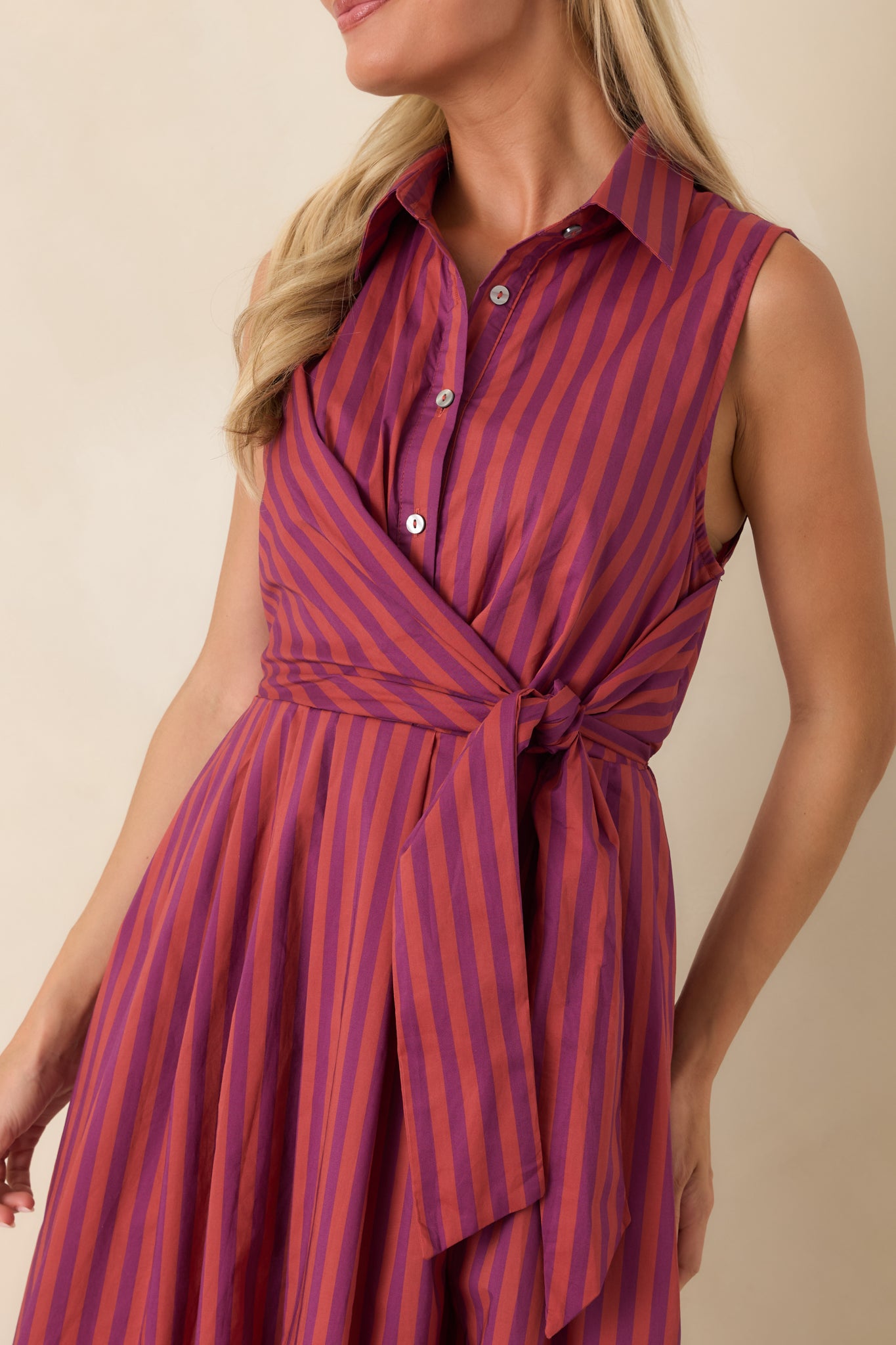 Close-up of the striped midi dress highlighting the pointed collar, button-front bodice, and layered tie waist detail.