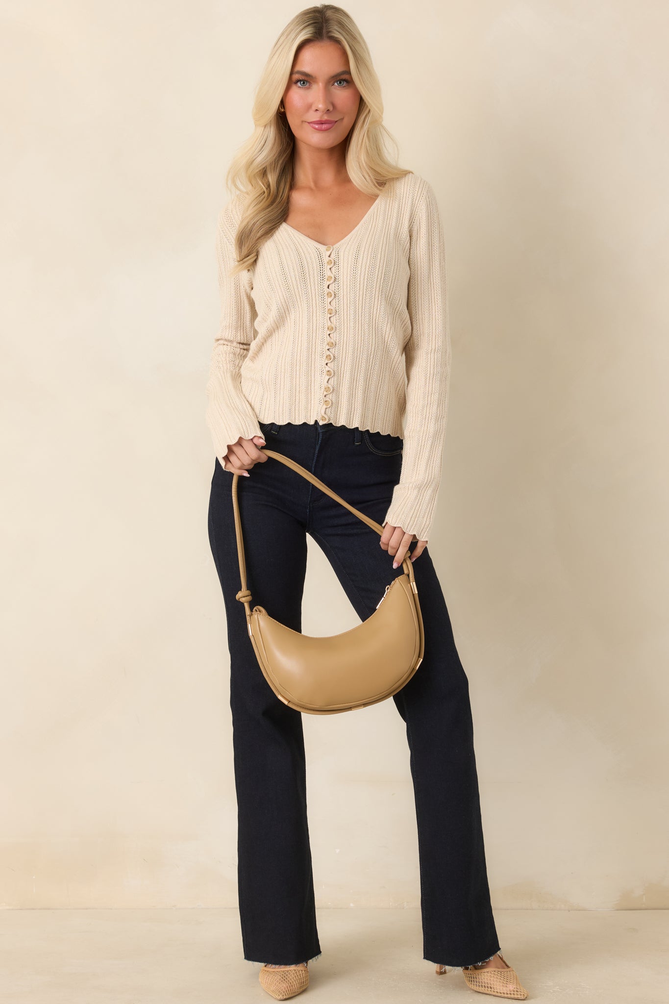Pointelle knit top featuring a V-neckline, functional front buttons, and a fitted silhouette.