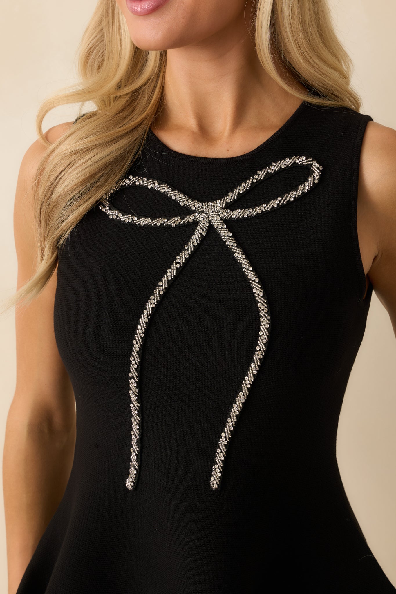 The top’s polished bow detail and structured front panel showcasing its refined design.