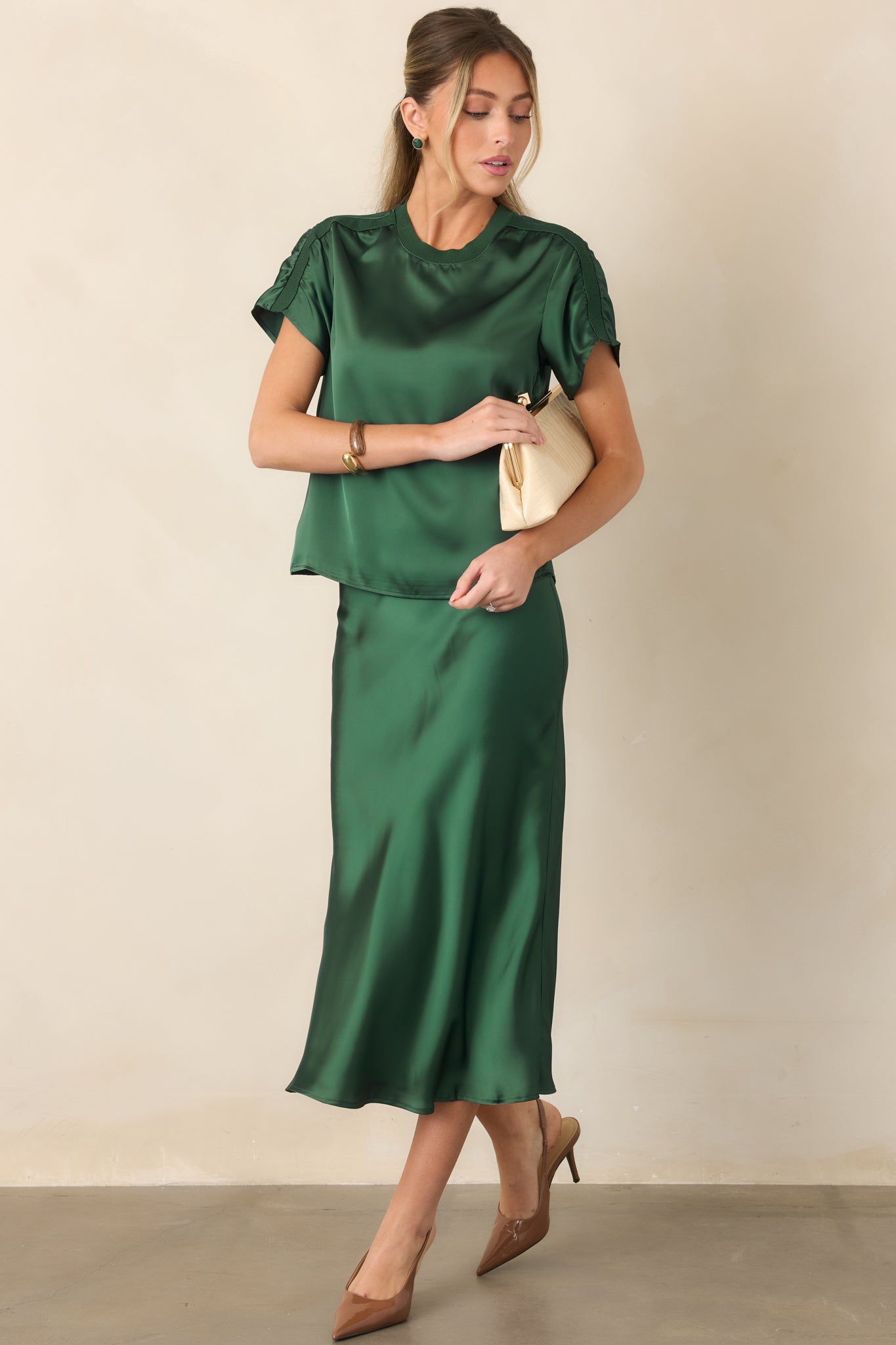 Polished satin top with an easy short-sleeve silhouette, softly lustrous finish, and textured ribbed accents along the neckline and shoulders.
