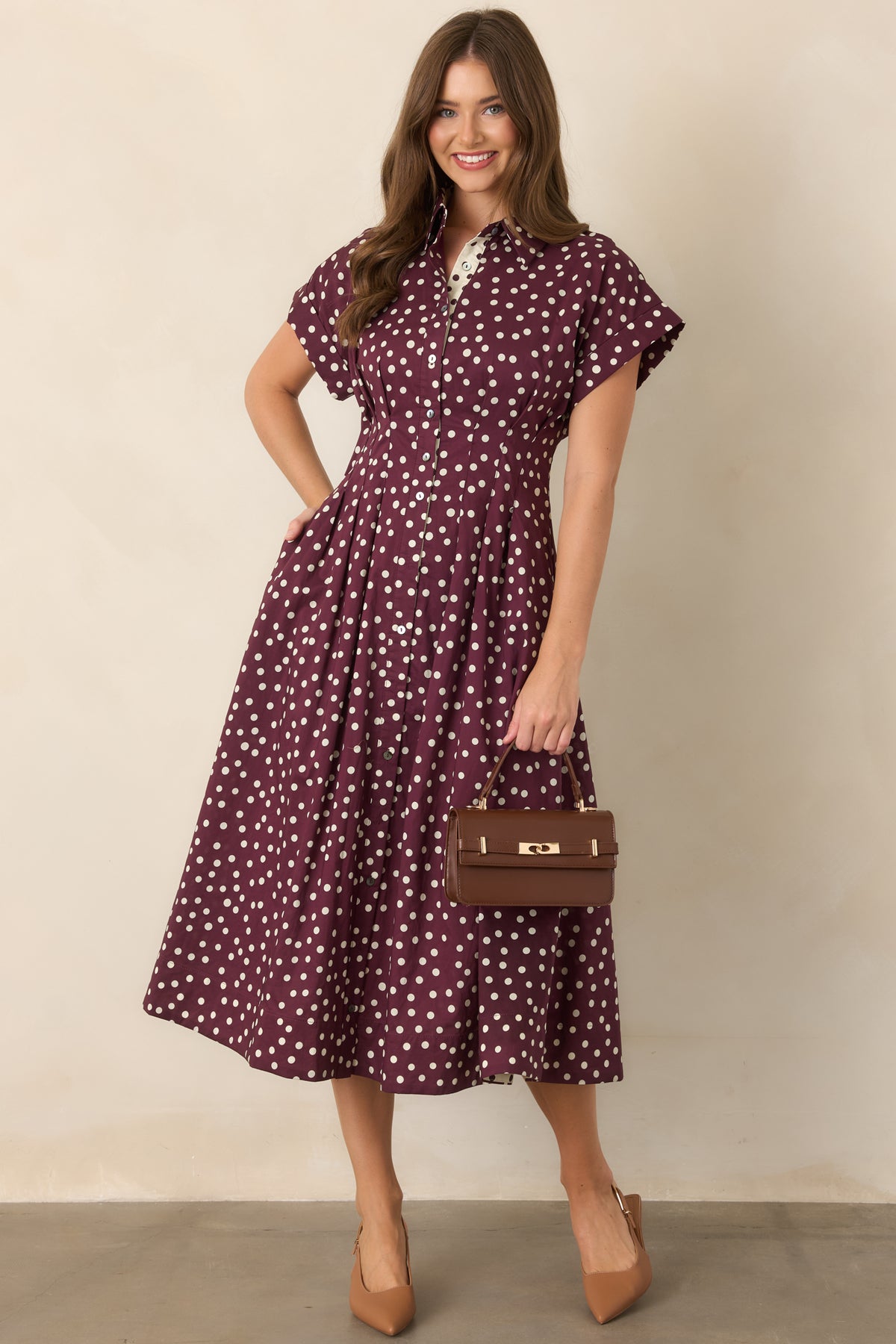 Polka dot fit-and-flare midi dress with a collared neckline, full button-front closure, short sleeves, defined waist, and flowing skirt.