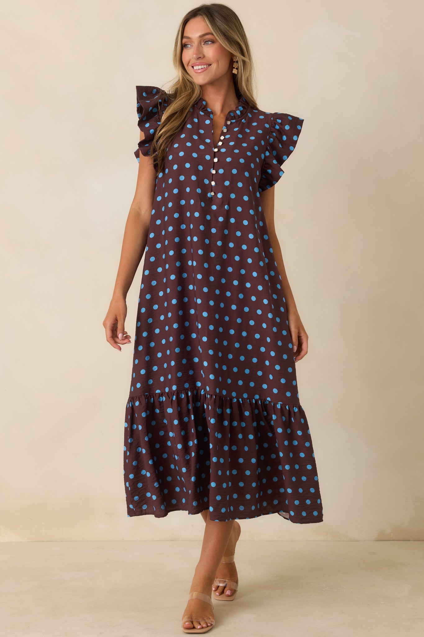 Polka dot midi dress with a relaxed silhouette, delicate neckline details, flutter sleeves, and hidden side pockets.