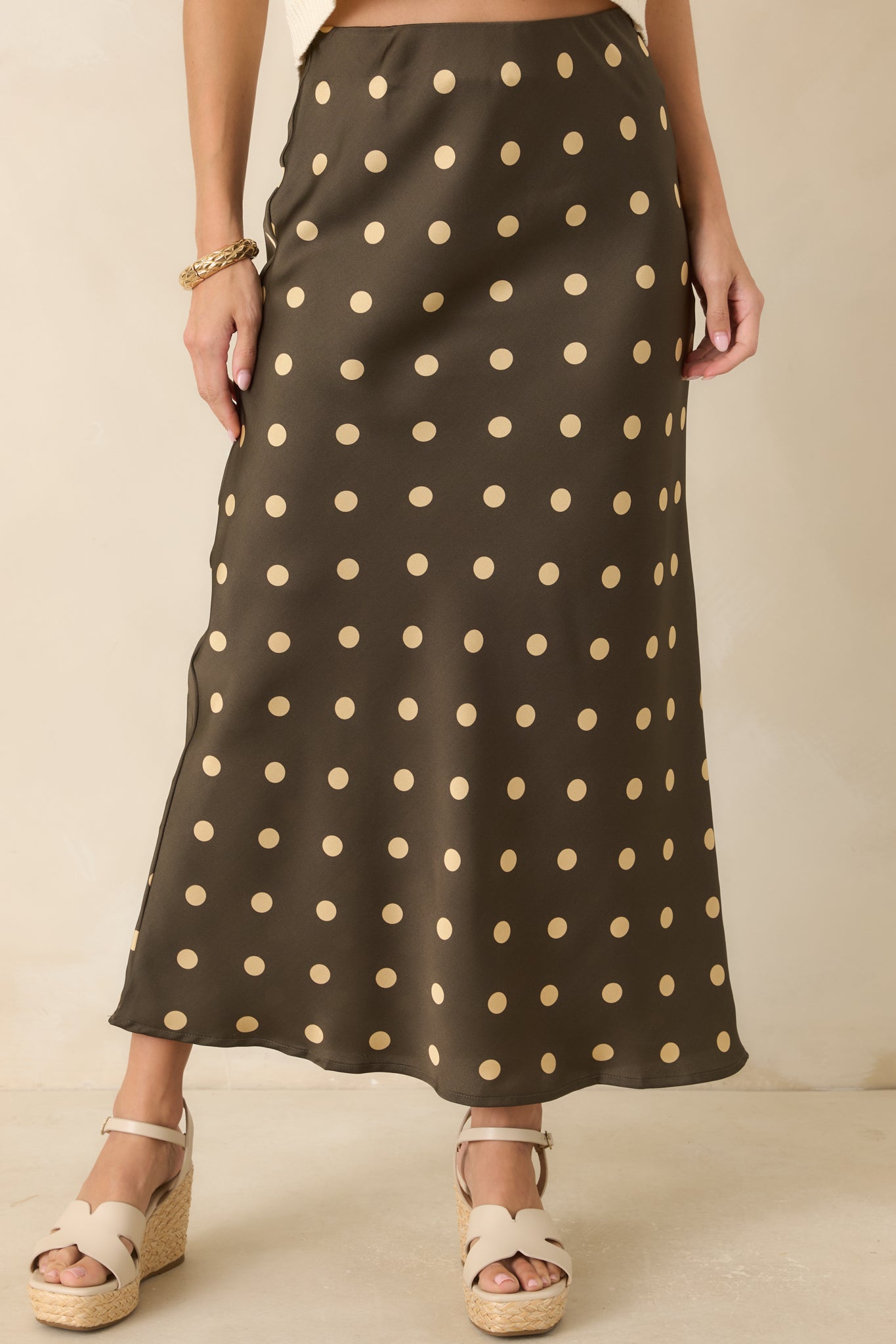 Polka dot satin skirt featuring a smooth bias-cut design and soft elastic waistband detail.