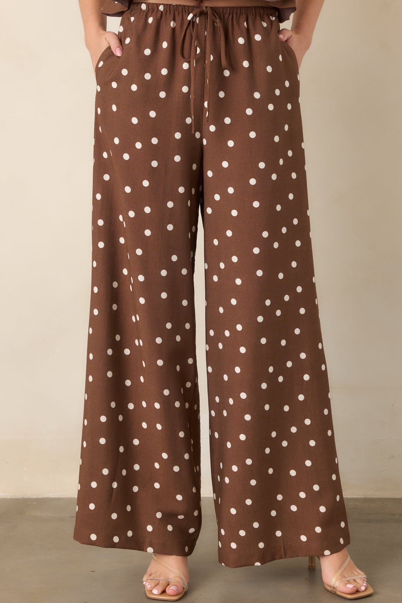 Detailed view of the wide-leg pants showcasing the evenly spaced polka dot print and relaxed drape through the legs.