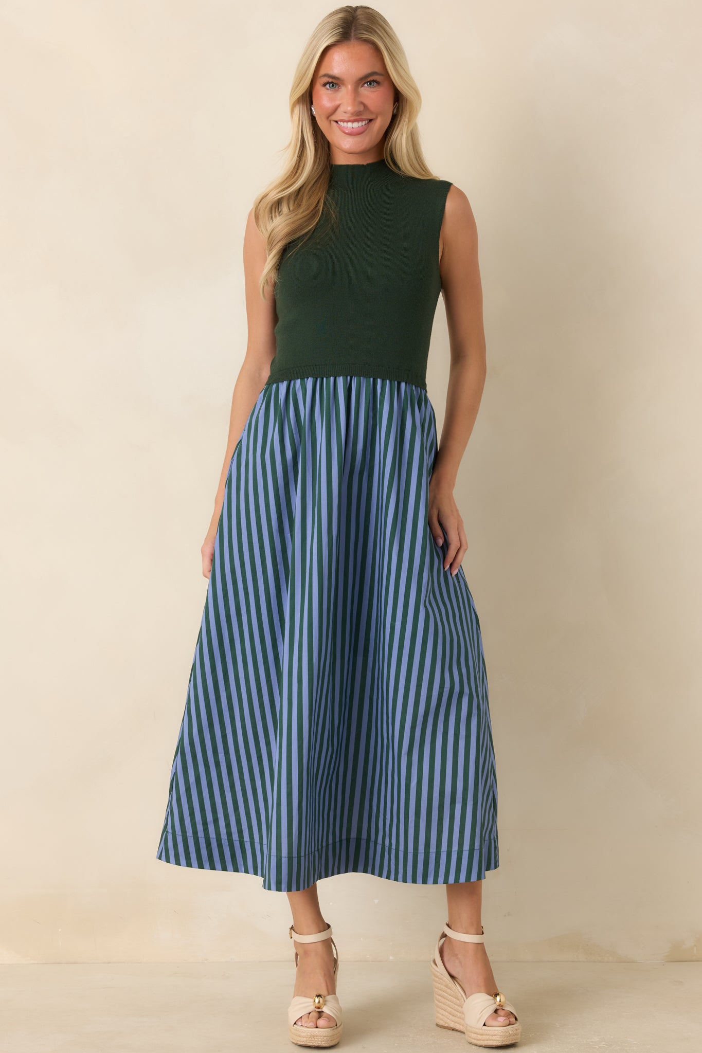 Preppy-inspired midi dress combining hunter green knit texture with light blue stripes and an elegant A-line silhouette.