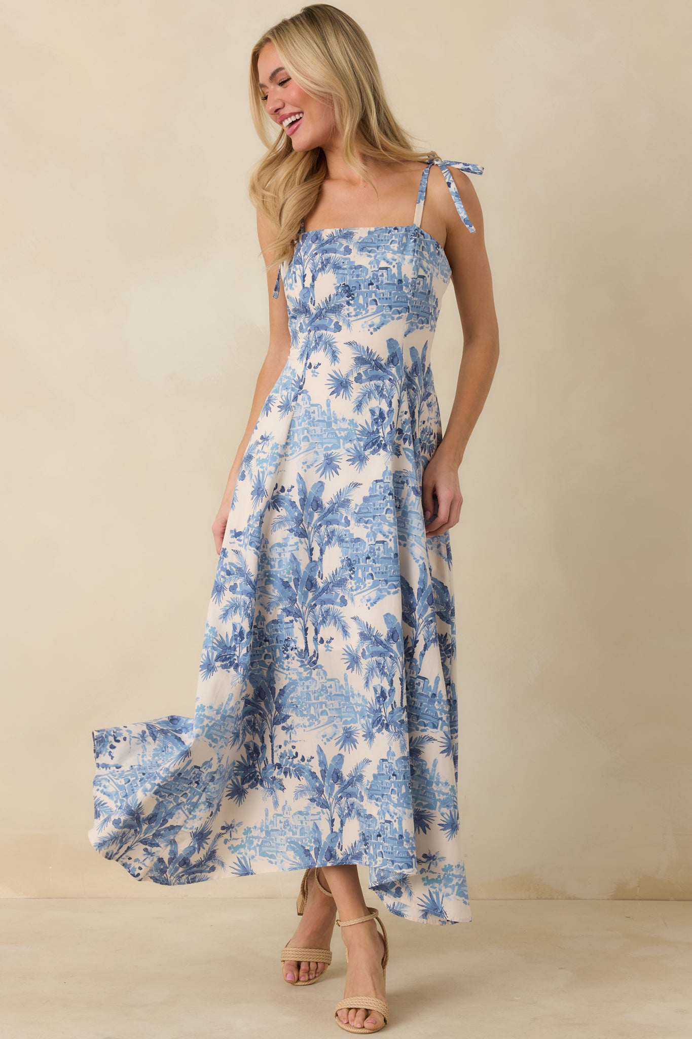 Printed blue and ivory maxi dress with structured bodice and fluid drape.