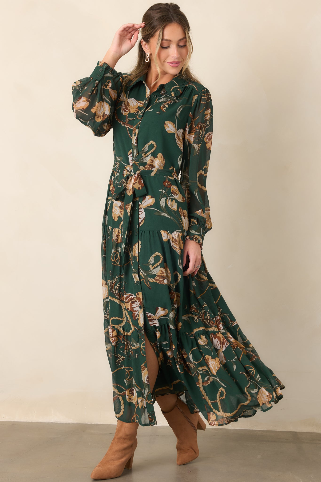 Printed maxi dress showcasing its refined collared neckline, button-front design, long sheer sleeves, and softly tiered skirt.