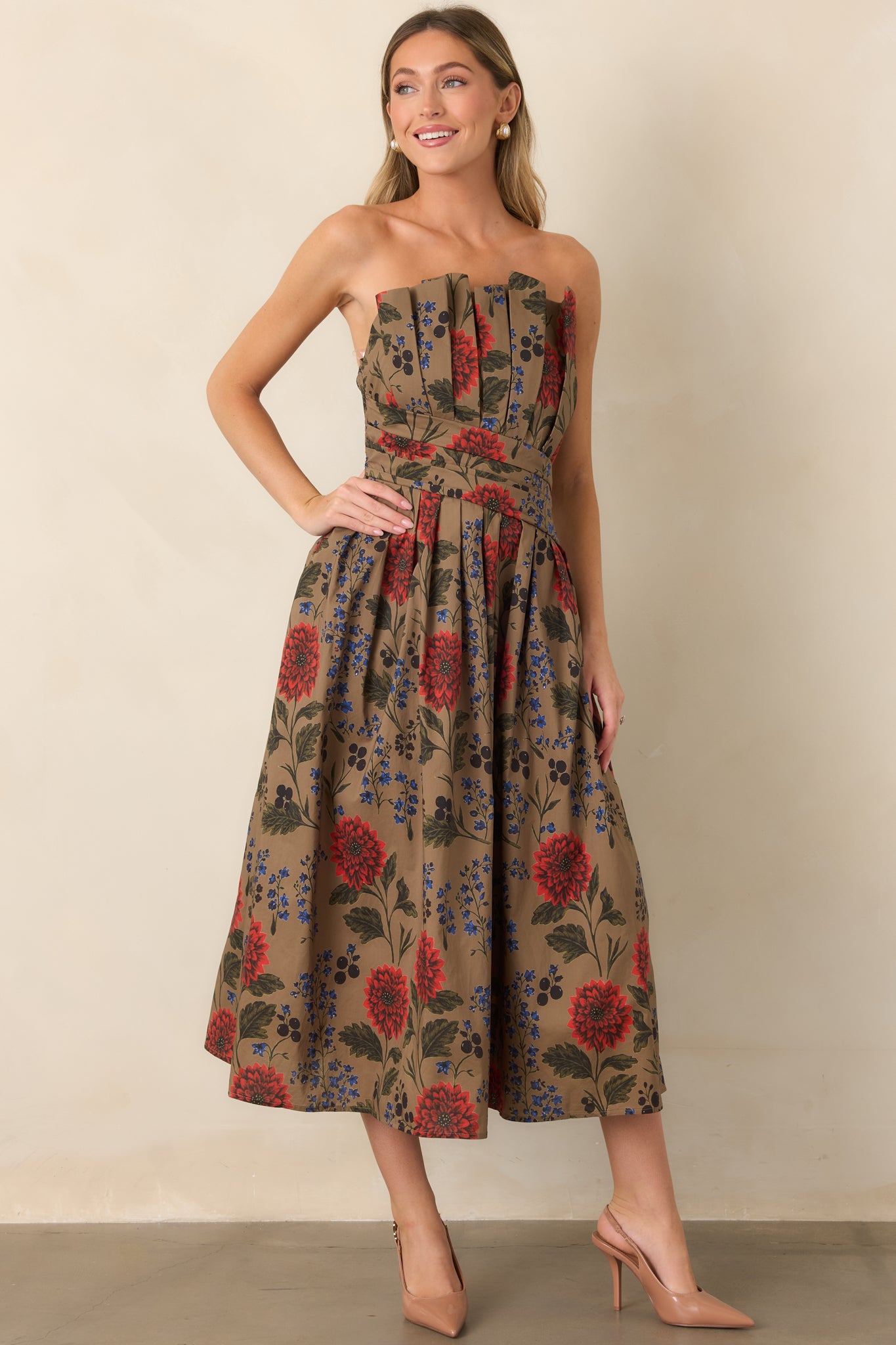 Printed cotton dress designed with a fitted strapless bodice and full midi skirt adorned with red flowers, blue blossoms, and olive foliage.