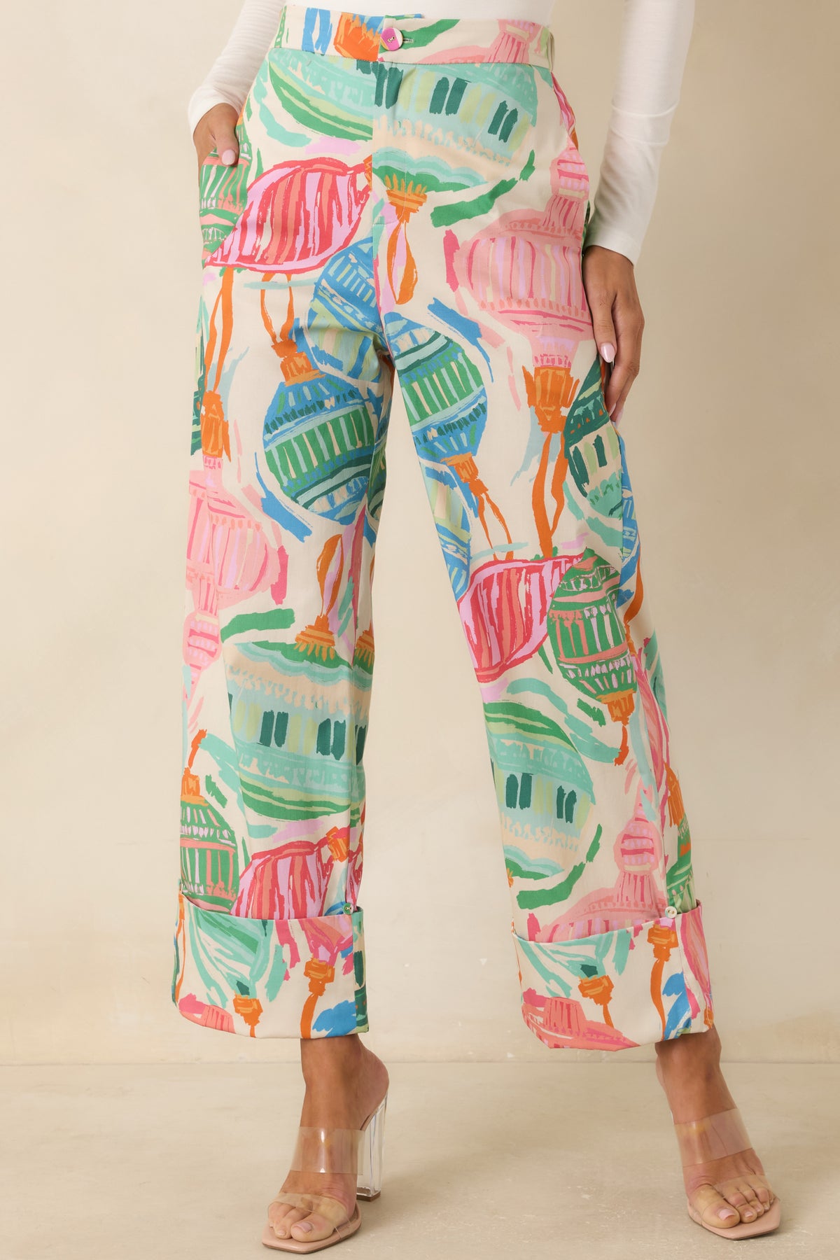 Flat front waistband with a fabric-covered button and zip closure on the printed pants.
