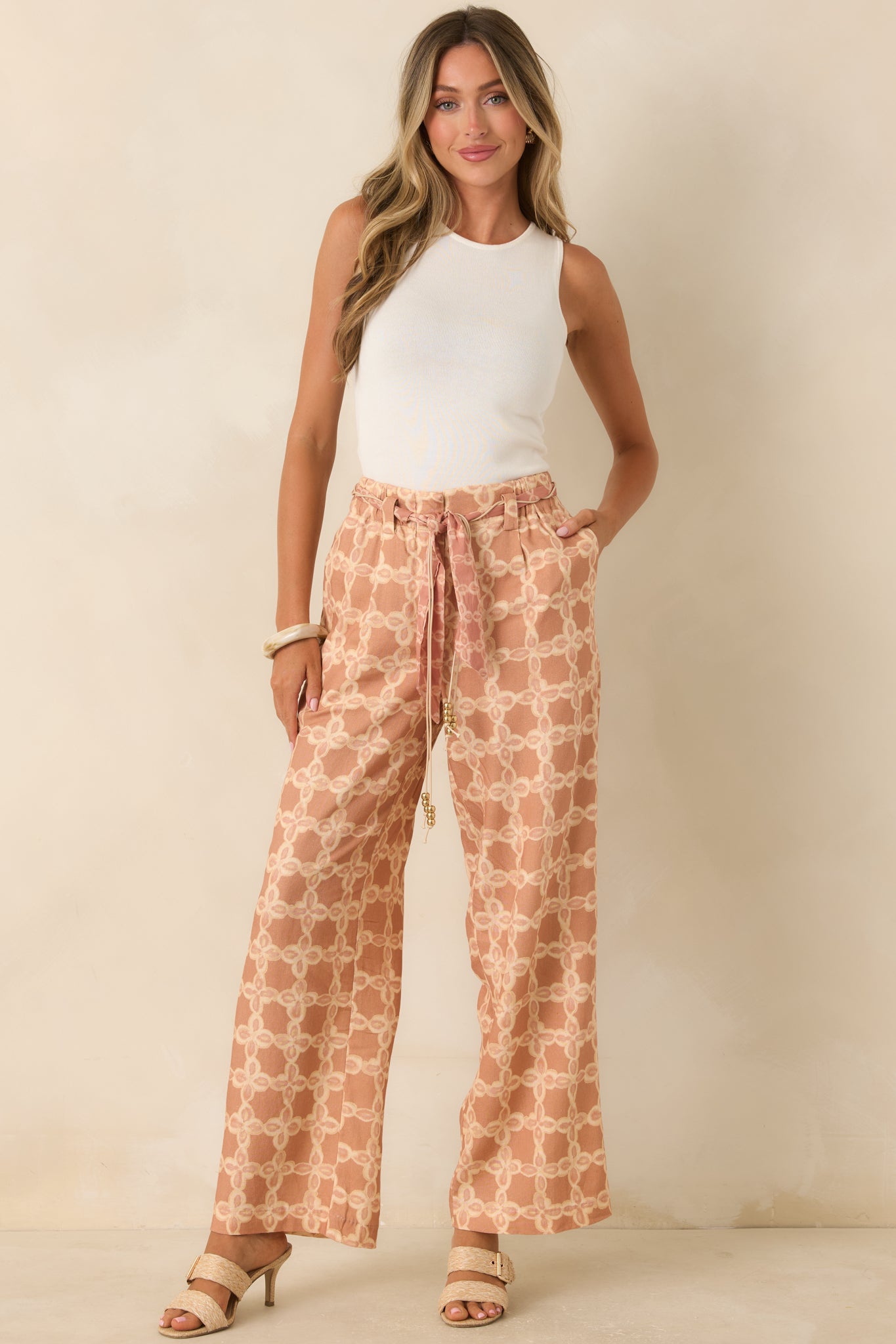 Breathable printed pants with a flowing wide leg design, high-rise waistband, and coordinating self-tie belt.