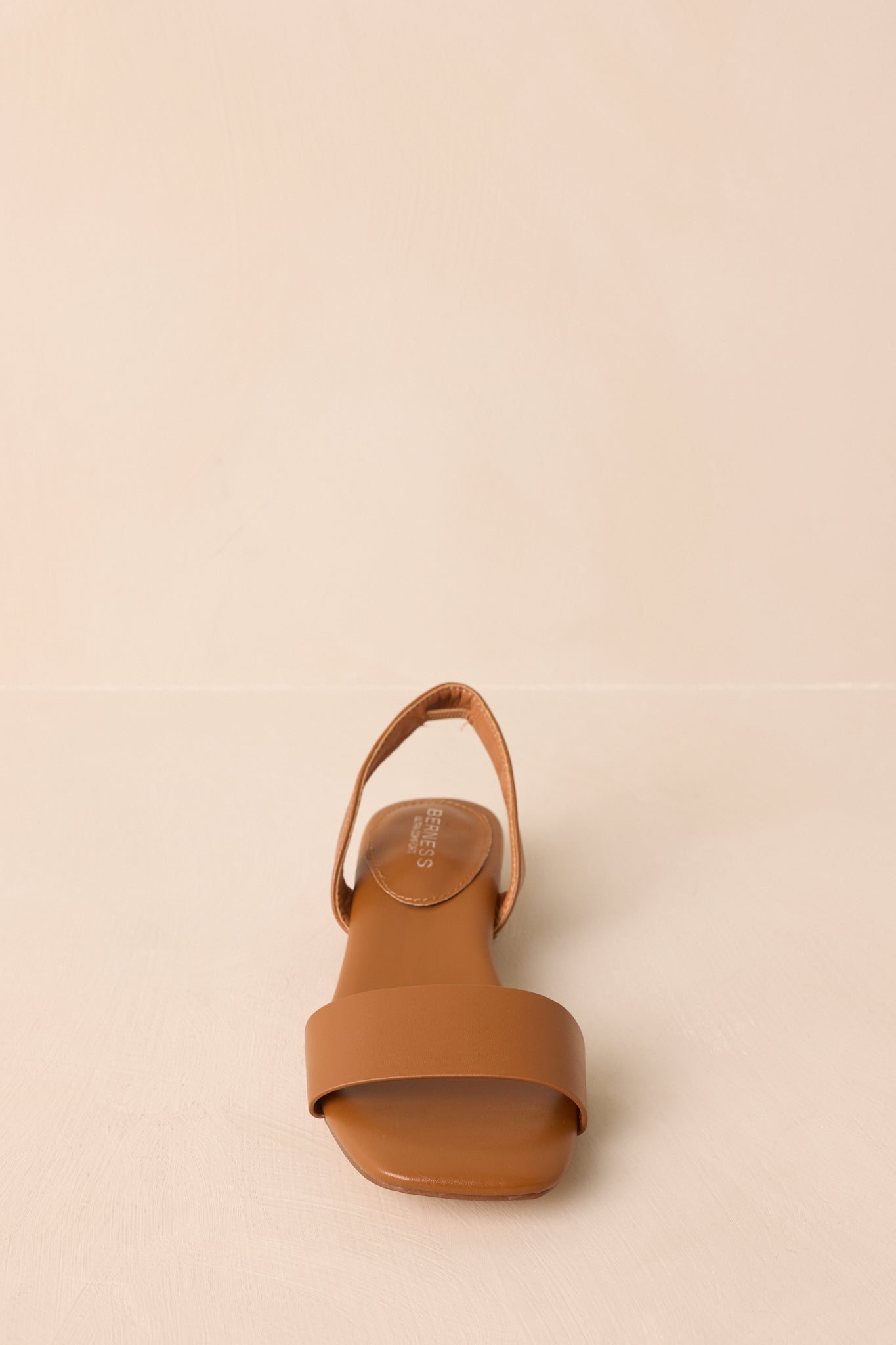 Profile view highlighting flat sole and sleek single strap silhouette.