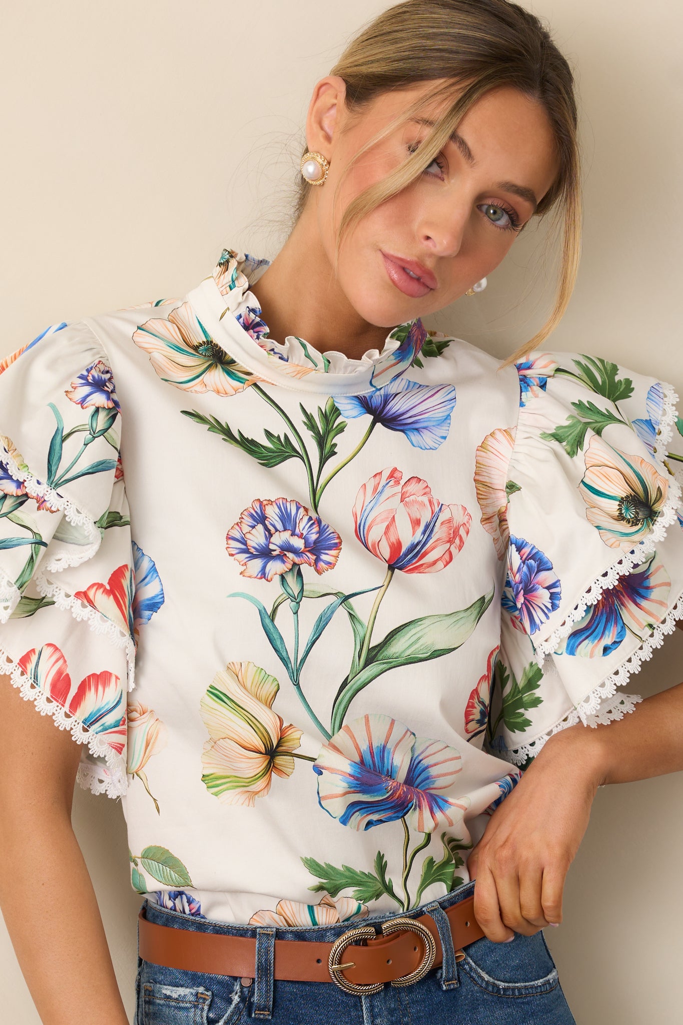 Cropped view highlighting the ruffle mock neckline on the floral top.